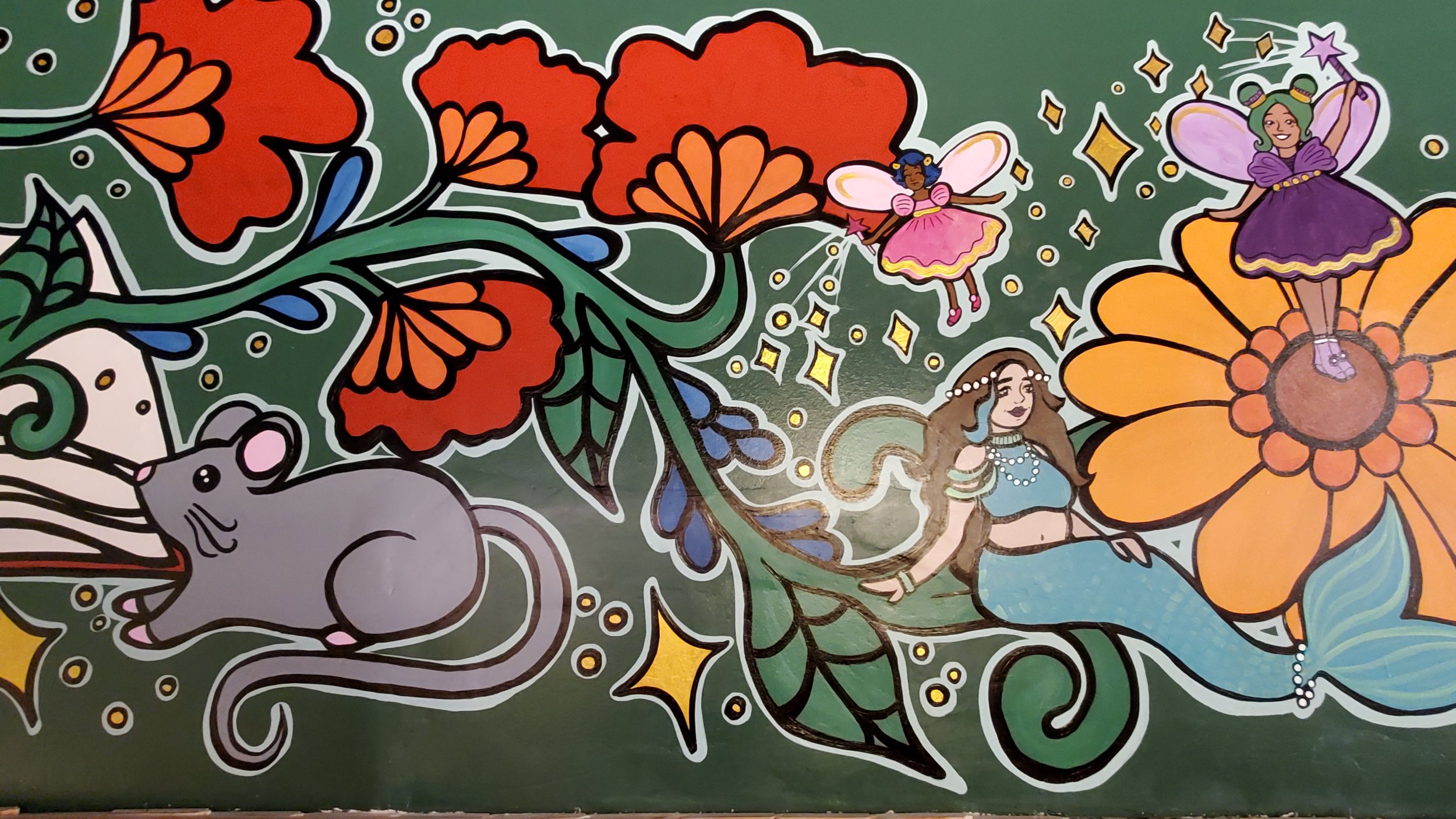 Detail of mural focusing on a mouse, red flowers on the vine, and a mermaid near a daisy, upon which a fairy stands