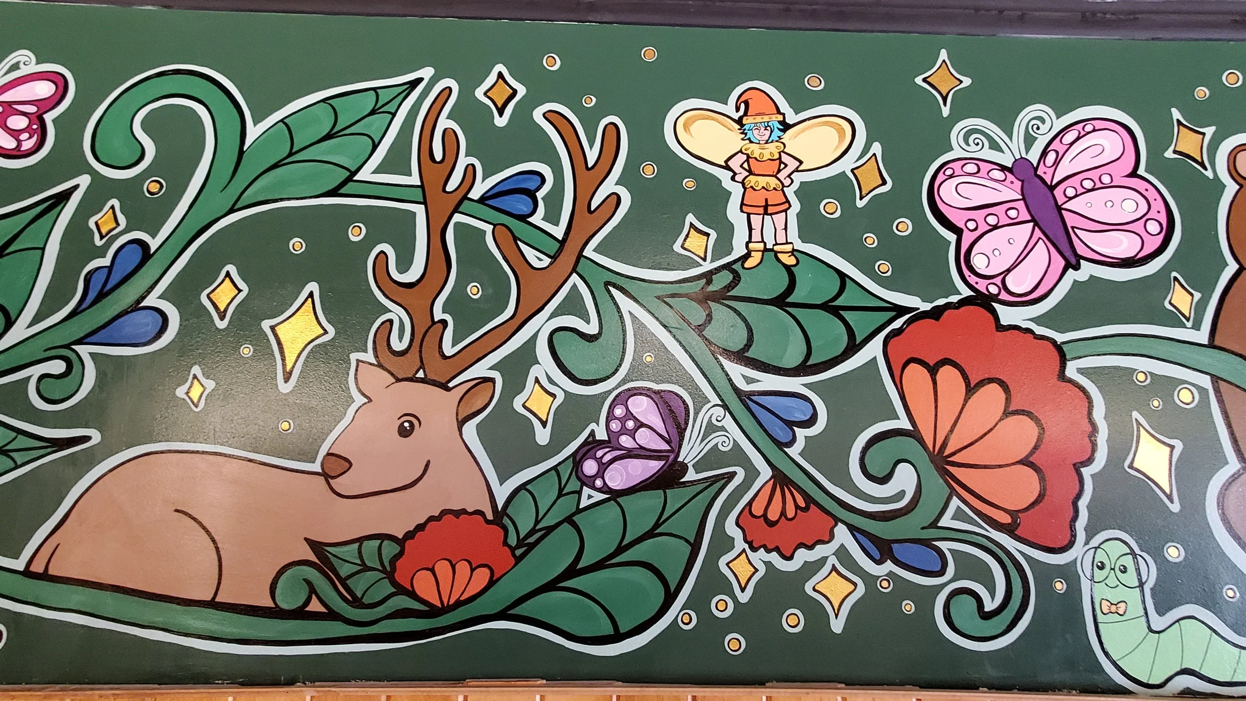 Detail of the mural, depicting a stag resting among leaves, a fairy standing on the vine above, and a bespectacled bookworm