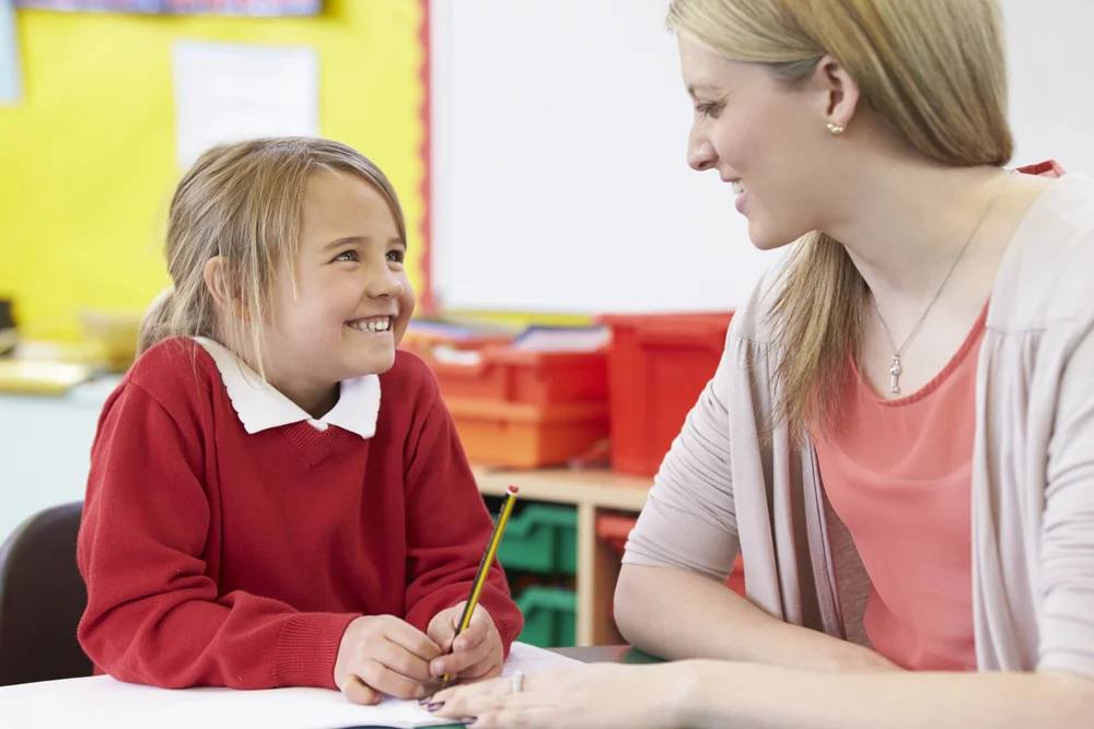 Child happily engaged in speaking with teacher