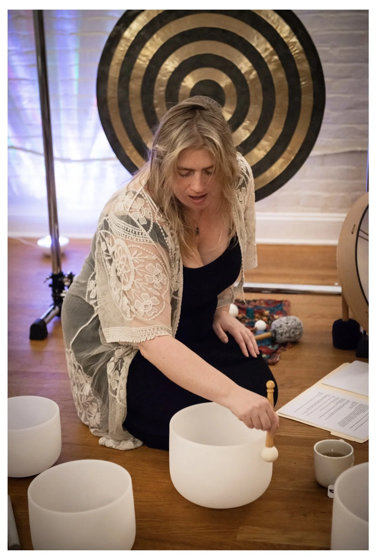 Alexandra playing crystal bowls in front of the gong teaching sound healing