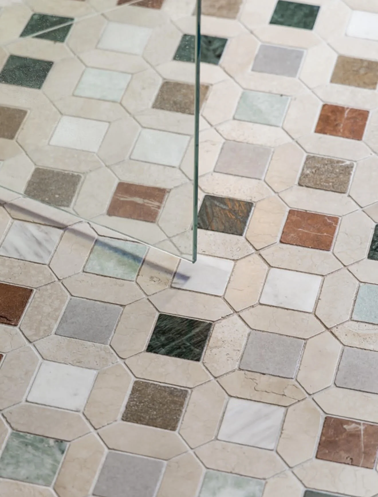 luxury natural stone mosaic bathroom floor featuring handcrafted designer tiles in a bespoke high end residential bathroom