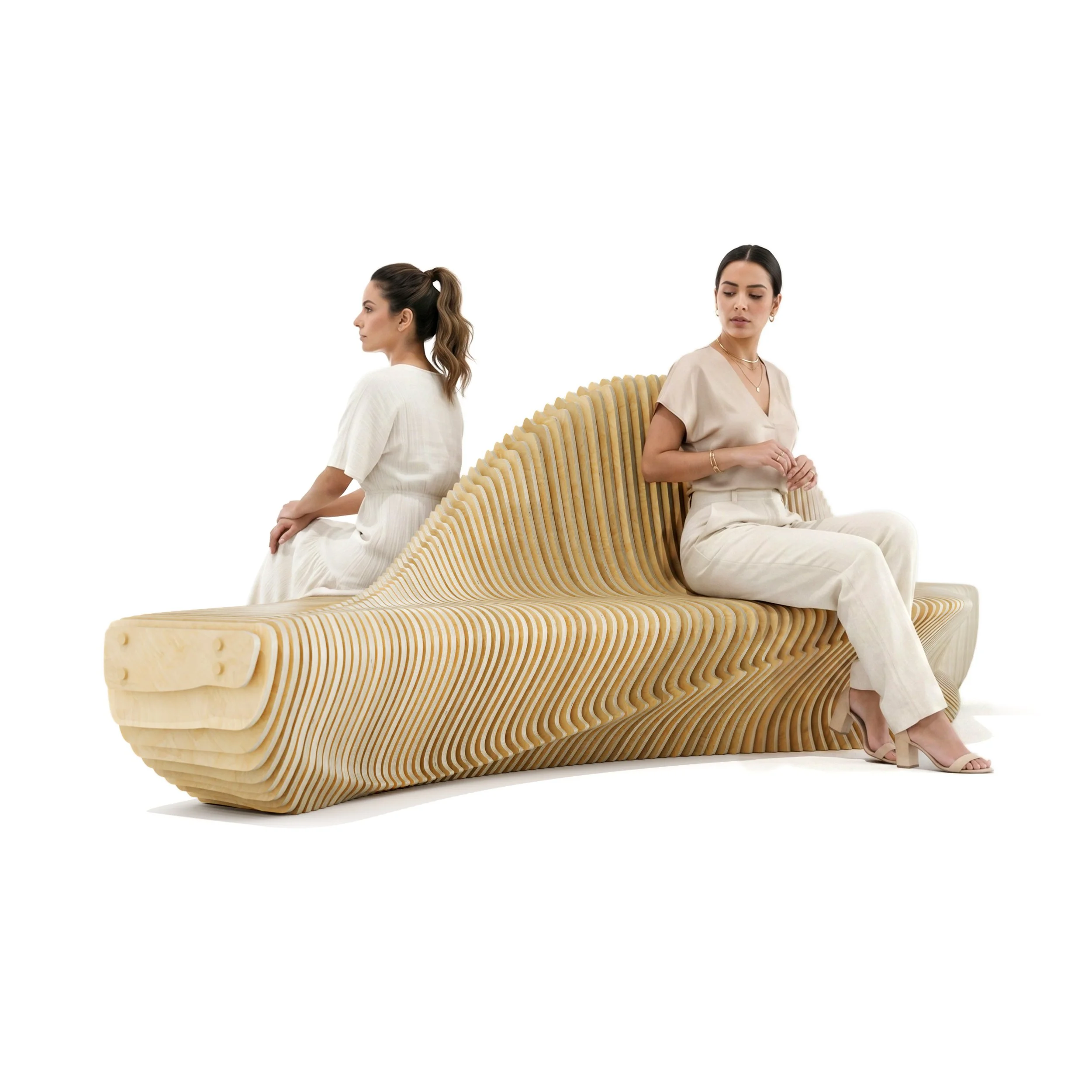 Two women sit back-to-back on a large, artistic wooden bench that resembles an aquatic wave-like shape, set against a plain white background.