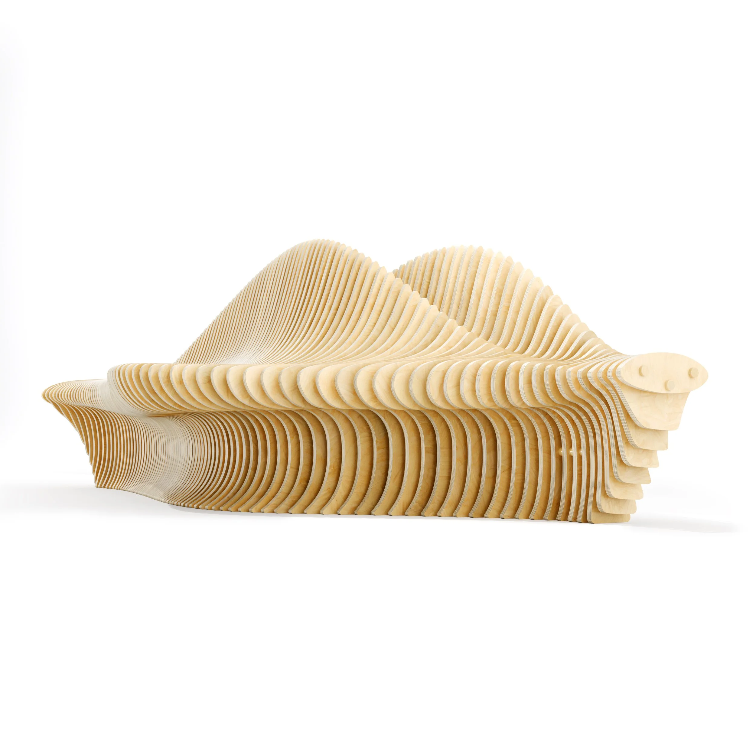 A wooden sculptural bench resembling a large, abstract wave pattern with curved, layered wooden slats, made in parametric style as a designer piece made by Terraform company designer Nick ODonnell.