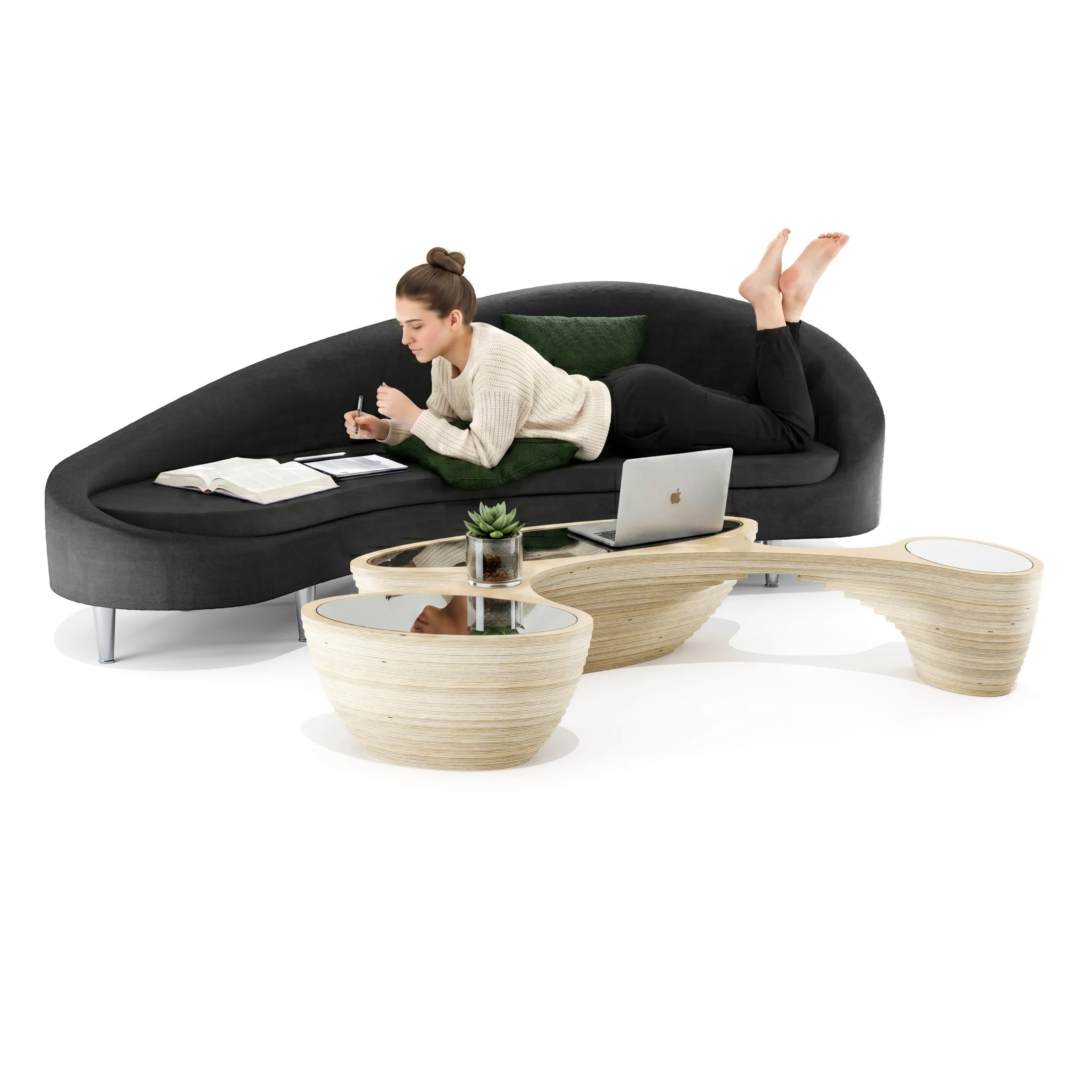 A woman lying on a dark gray sofa with her upper body propped on rainbow pillows, reading a book with open notebooks nearby, and a silver laptop on a wooden parametric style coffee table with a small potted plant in front of her.
