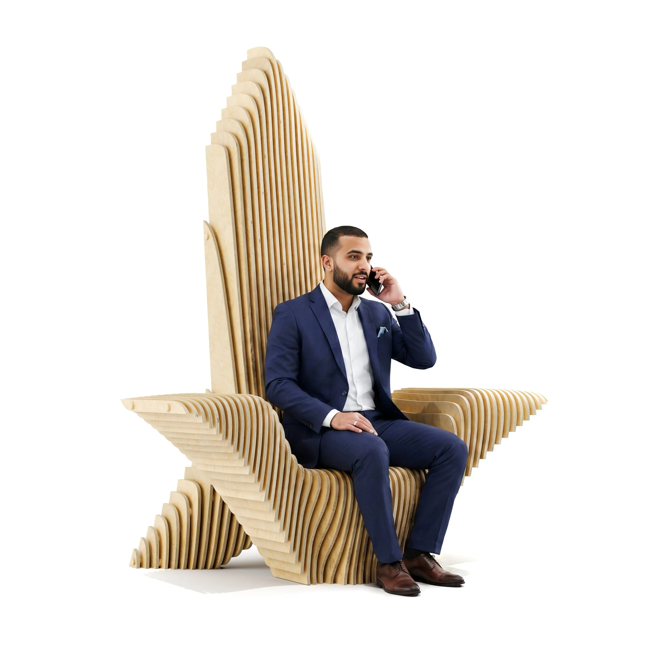 A man in a blue suit sitting on a bespoke sculptural wooden chair made in a parametric style with a high backrest designed with multiple layers of curved wooden slats, talking on a mobile phone.