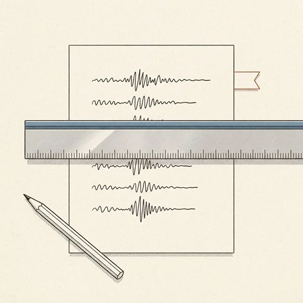 A steel pica rule lying across a proof sheet beside a small flag tab.