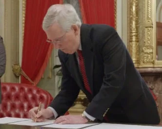 Sen. Mitch McConnell (R - KY) signs the 2018 Farm Bill with a pen crafted from hemp