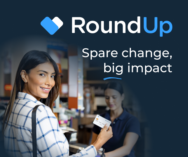 Smiling woman at a checkout holds a card; text reads RoundUp, Spare change, big impact.