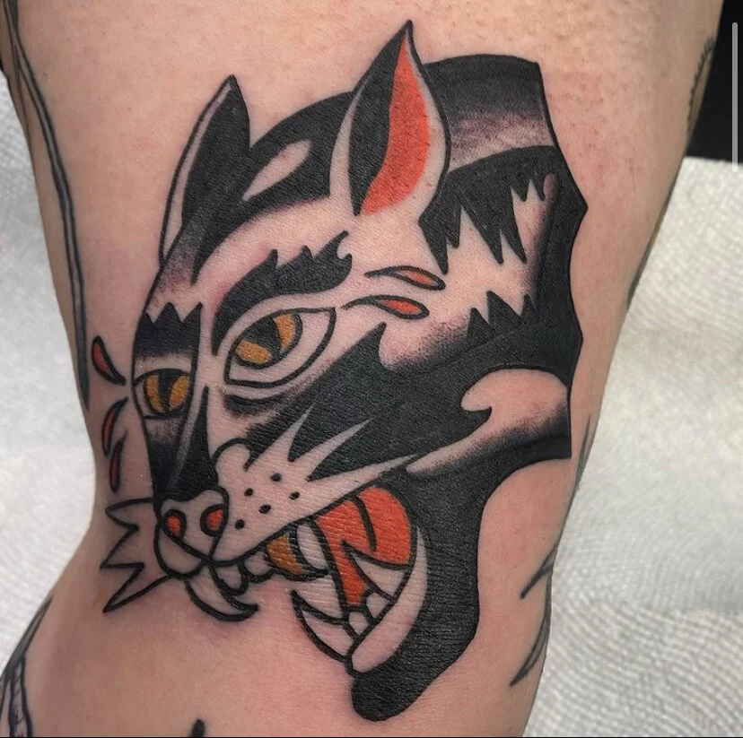 Black cat tattoo on arm