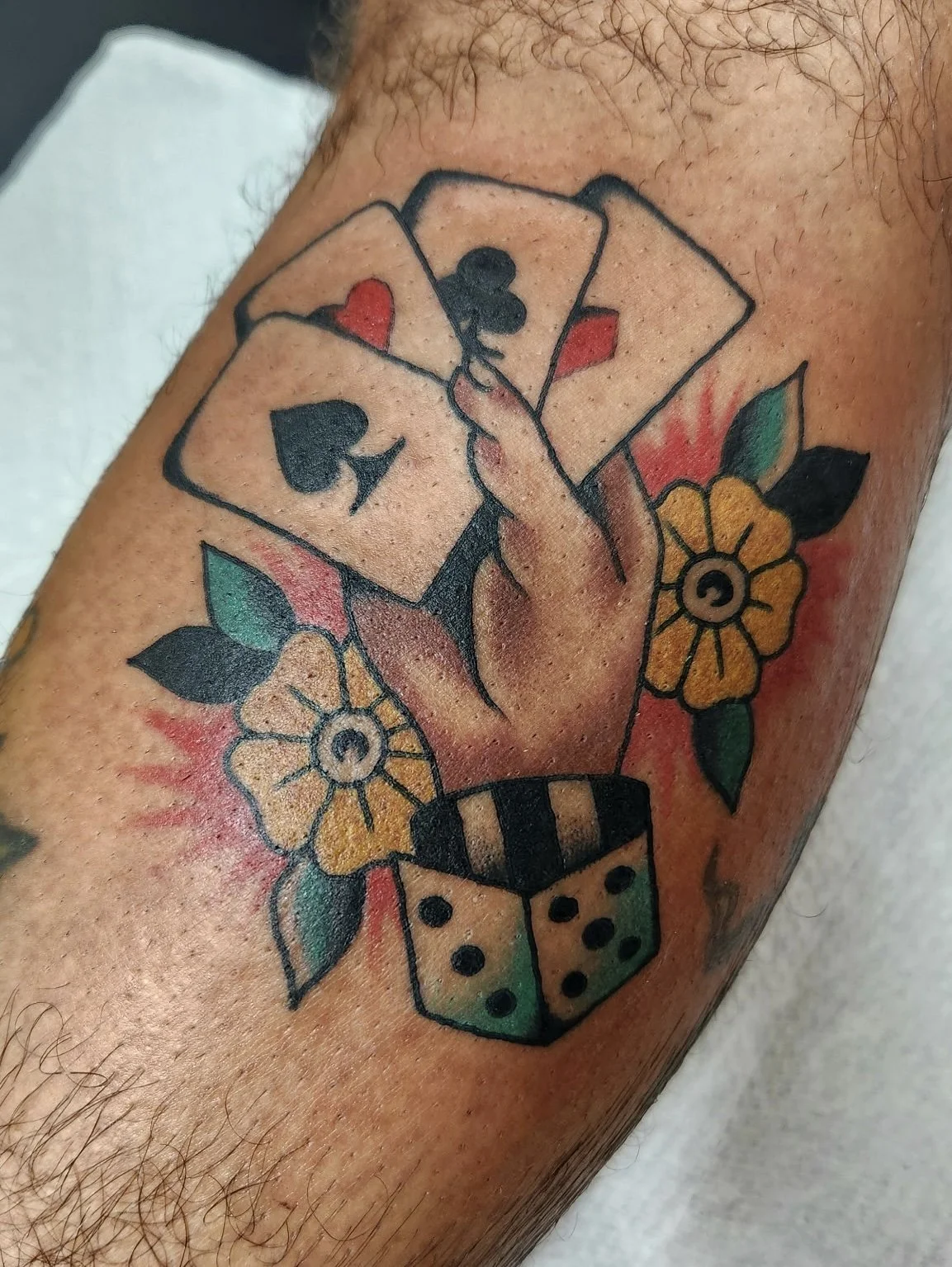 American traditional tattoo of a hand holding playing cards in classic flash style