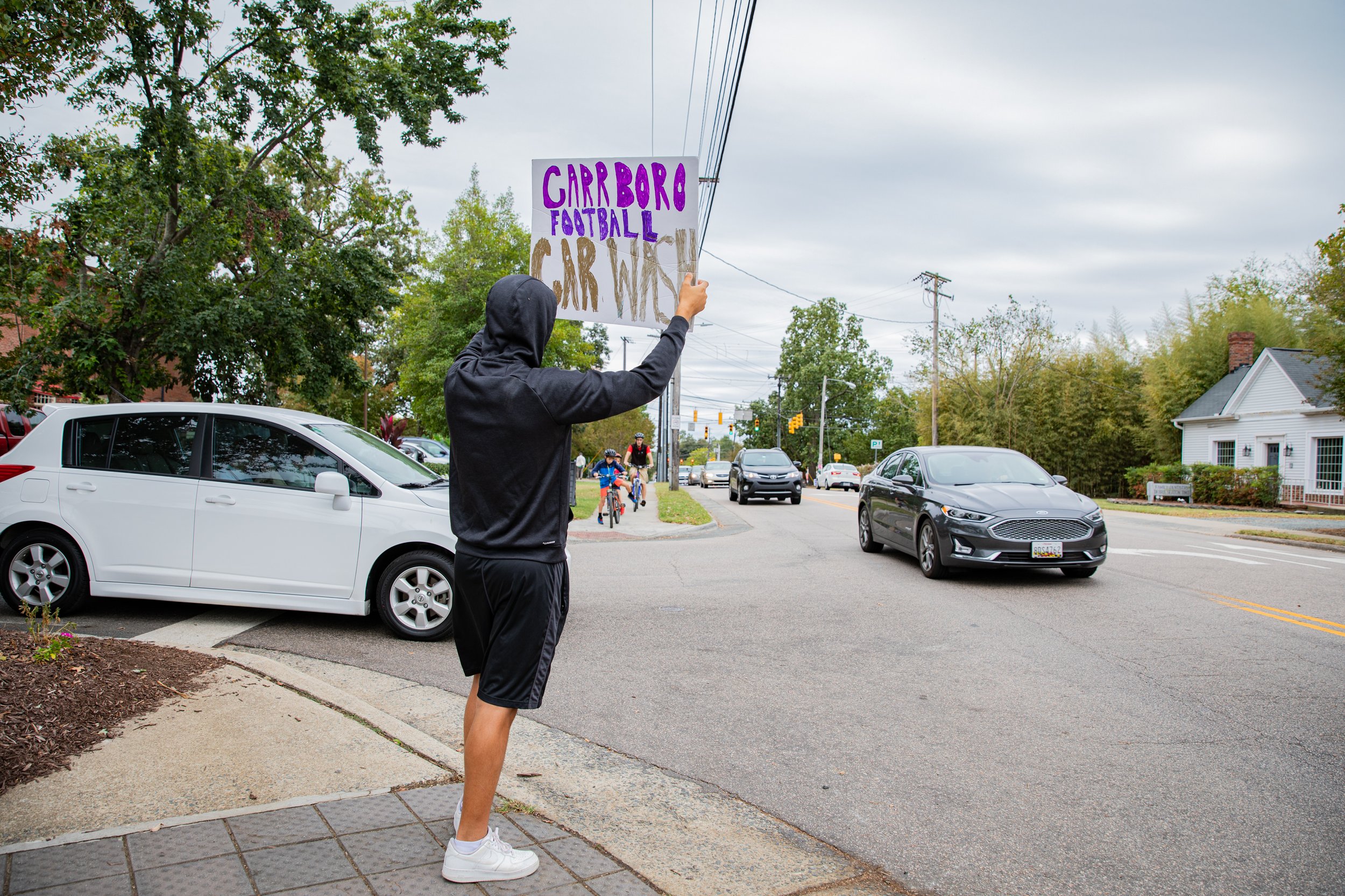  Junior Phoenix Tudryn holds up a sign advertising the team’s fundraising car wash. “Compared to bigger schools and programs, we do not get a lot of funding, but I think we do a good job of maximizing what we do get to better our program as a whole. 