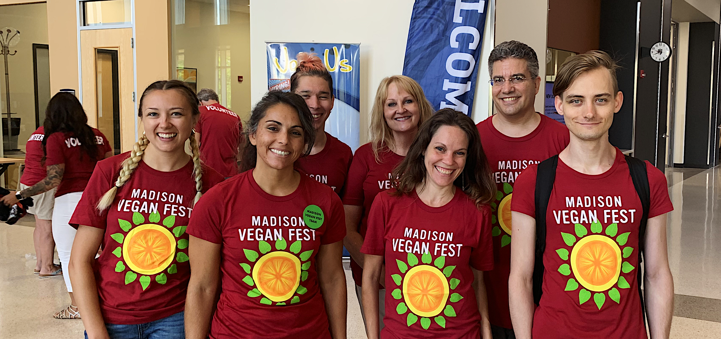 A group of Madison Vegan Fest volunteers posing for a photo in their red Madison Vegan Fest T-Shirts