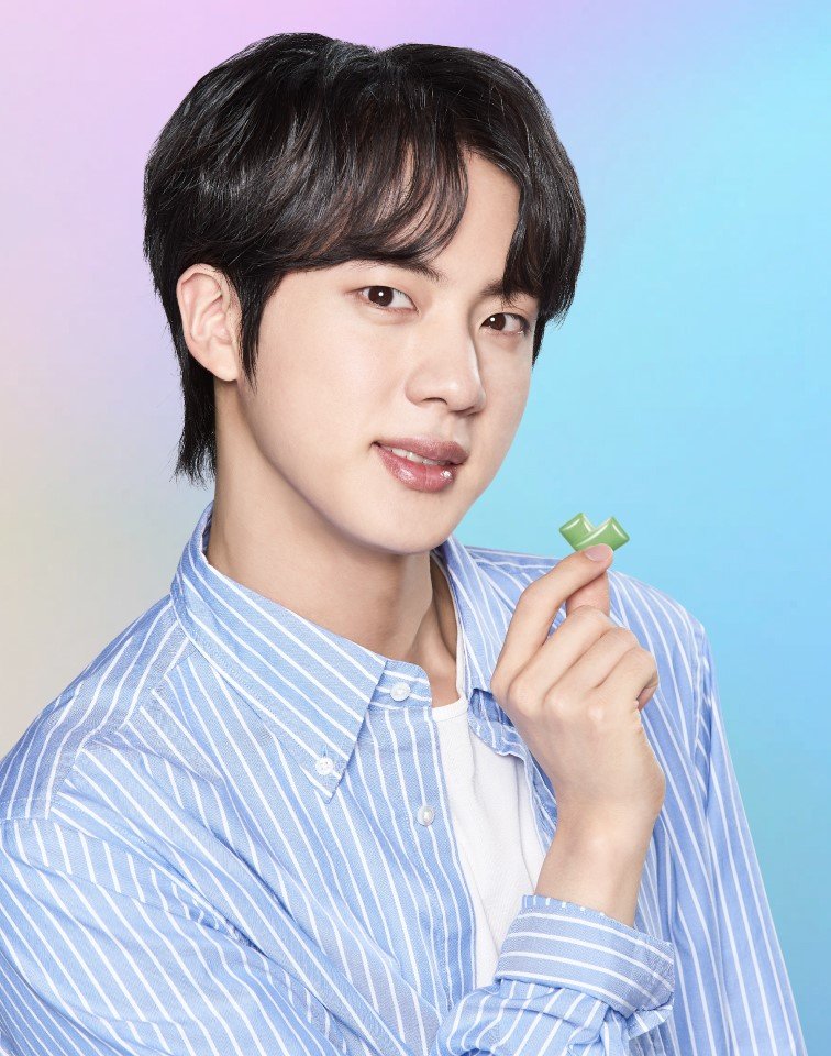 Jin poses holding with BTS Xylitol gum