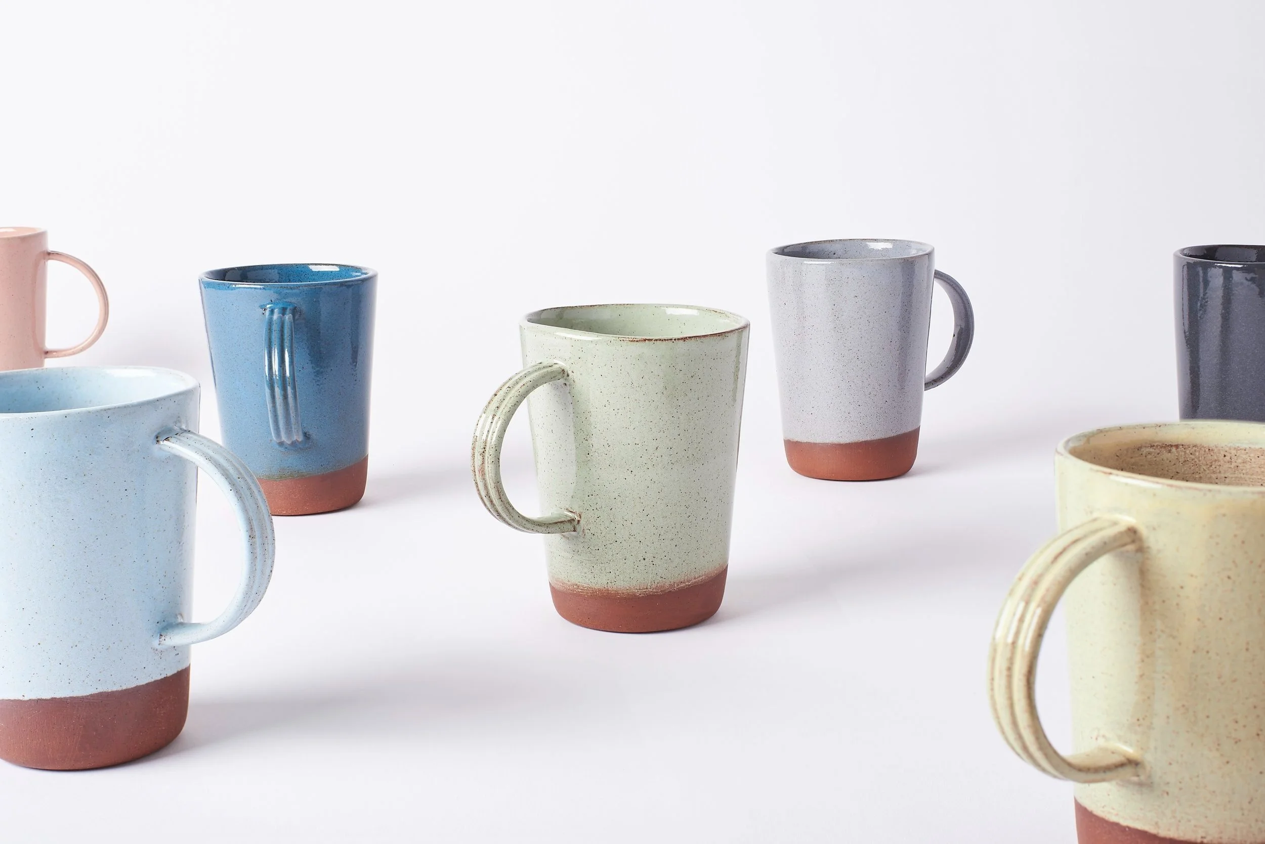 Set of handmade ceramic terracotta cups in modern colours