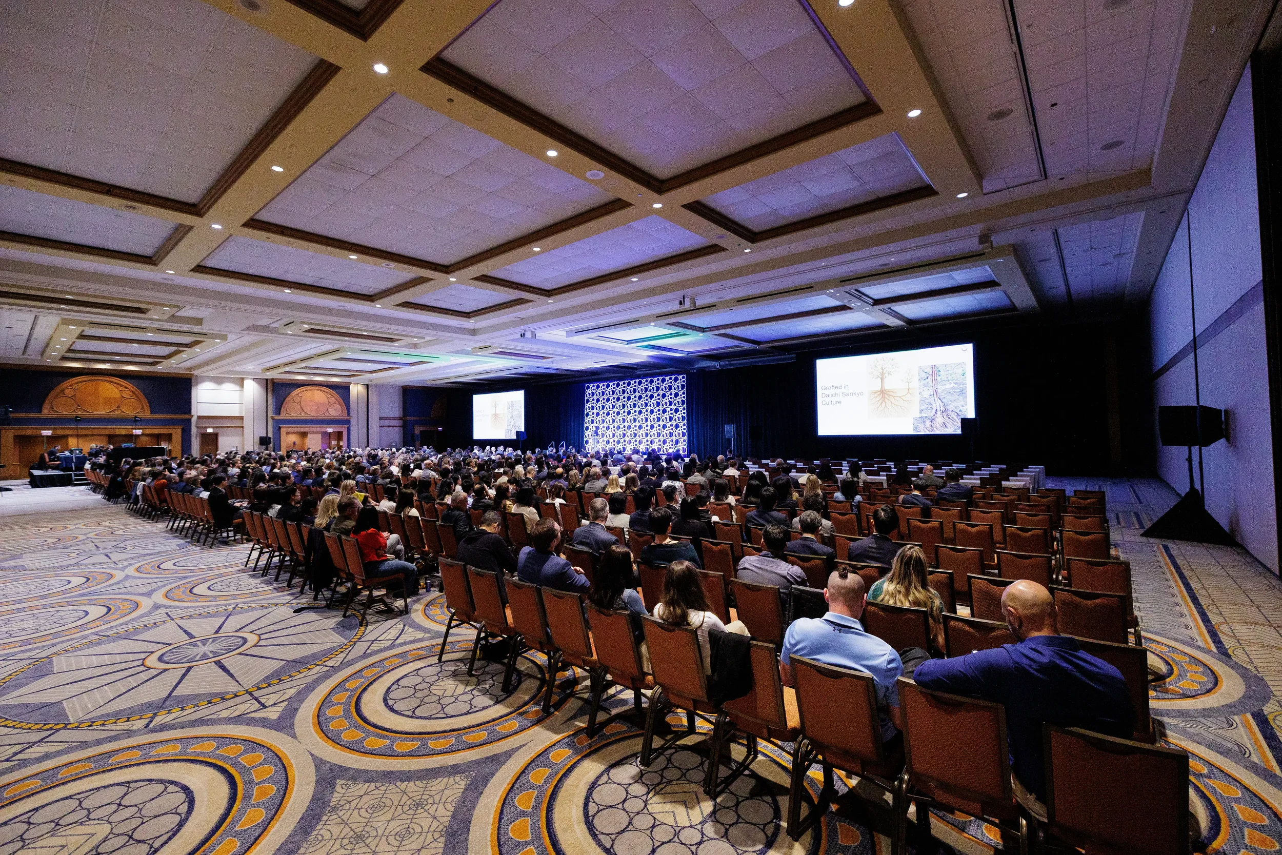 Wide view of seated audience watching presentation in ballroom at Chicago corporate conference