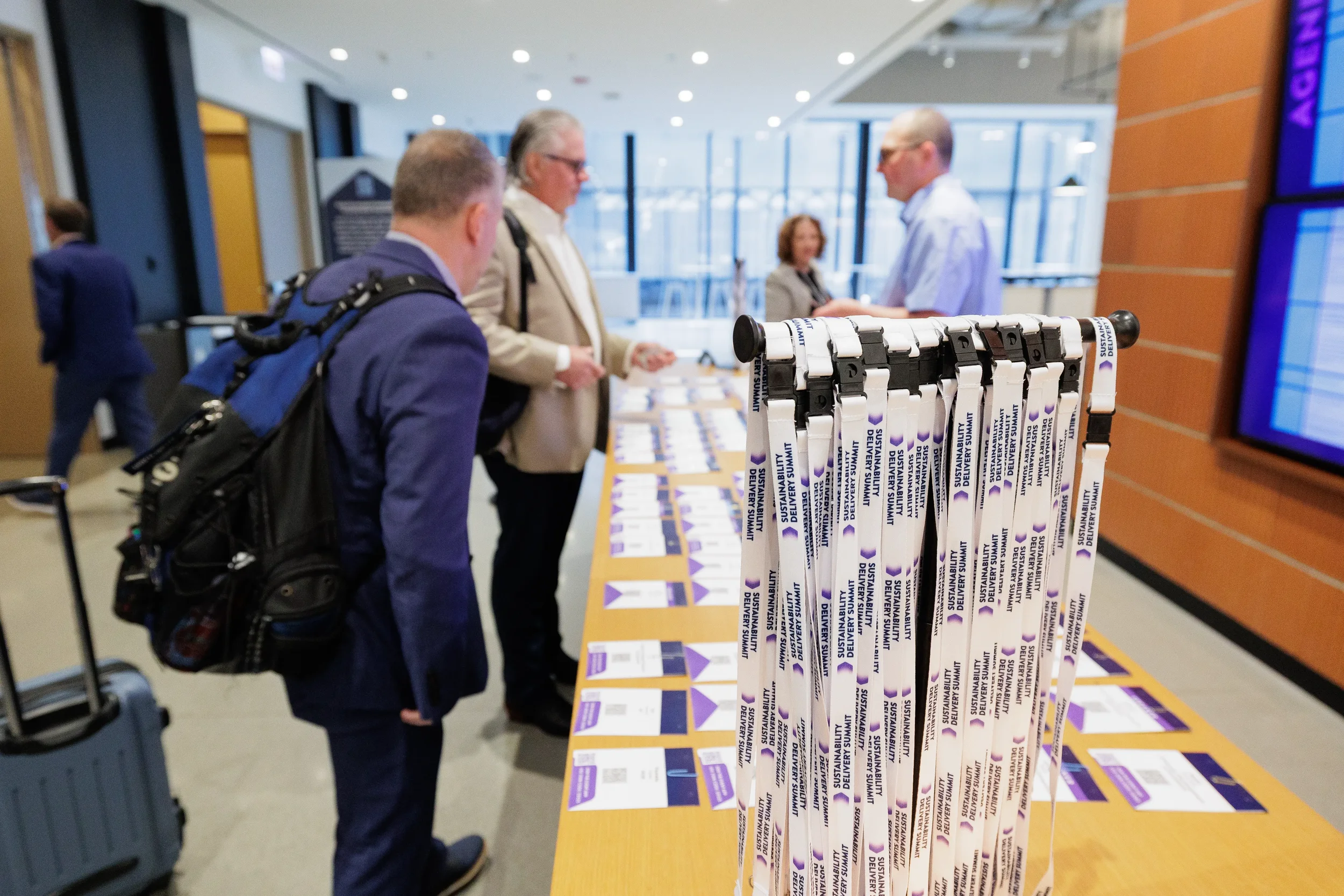 Attendees check in at registration table with lanyard display at Chicago industry conference