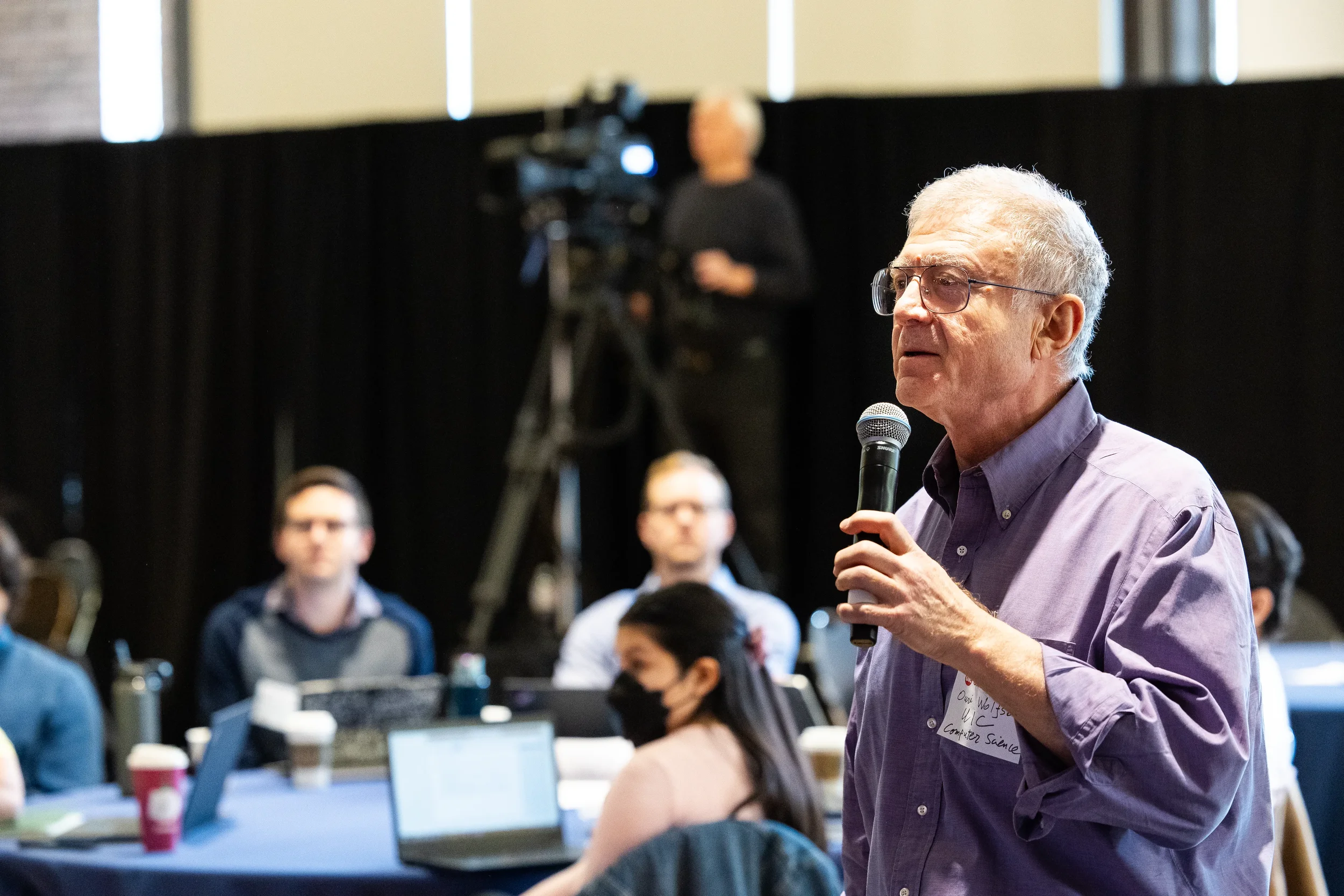 Attendee stands with microphone to ask question during Q&A at Chicago industry conference