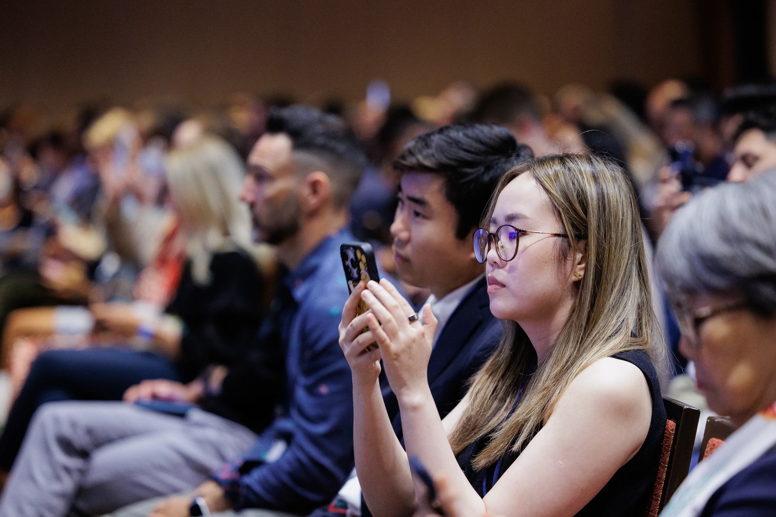 Attendee photographs presentation on phone during Orlando industry conference session