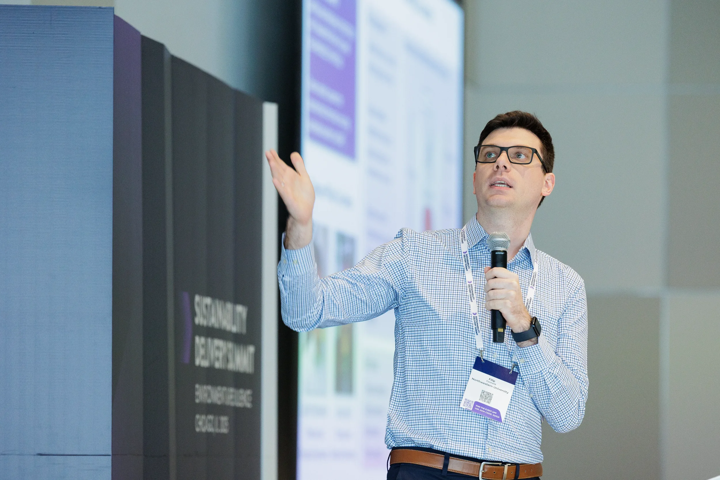 Speaker gestures while presenting with microphone at Orlando corporate conference session