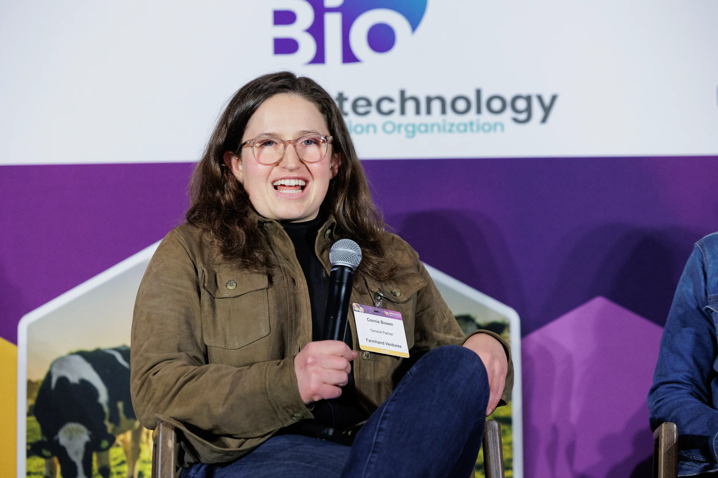 Panelist laughs while speaking into microphone during seated discussion at Orlando industry summit