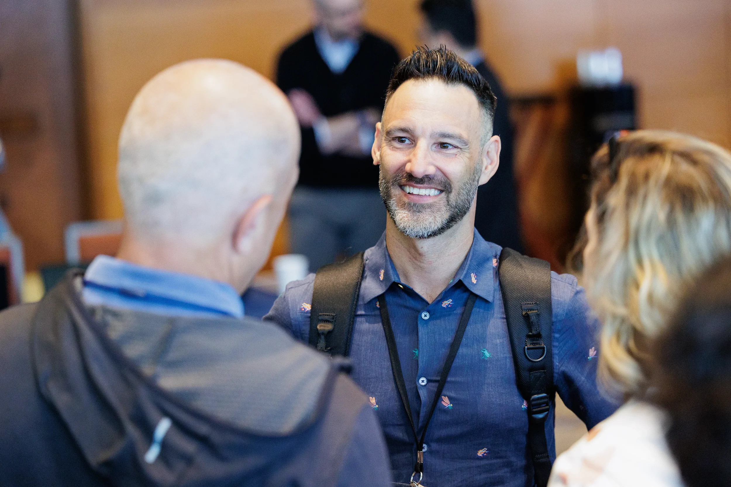 Attendee smiles while conversing with colleagues at Chicago corporate conference