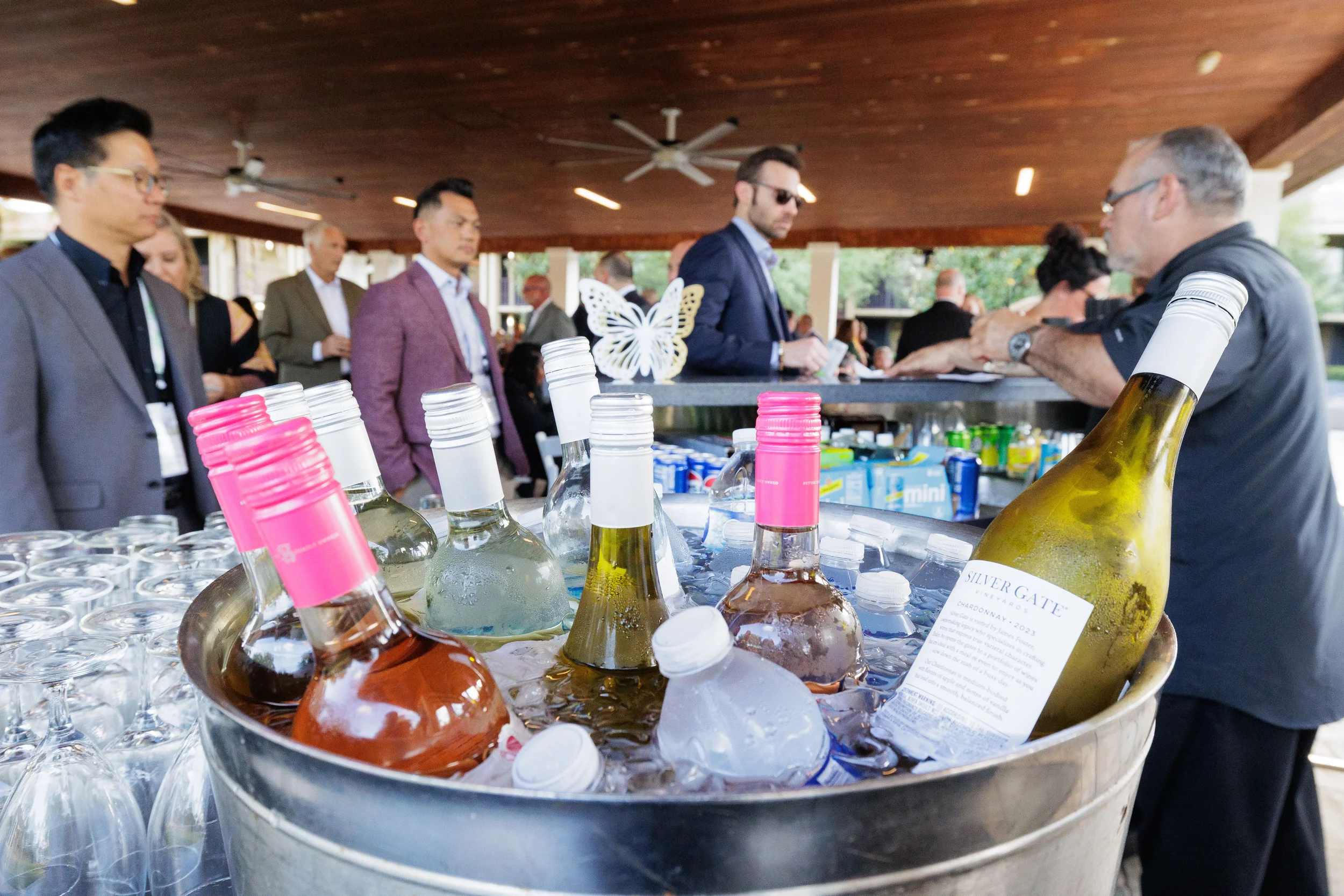Assorted wine bottles chilling in ice bucket at outdoor pavilion bar during Orlando corporate event