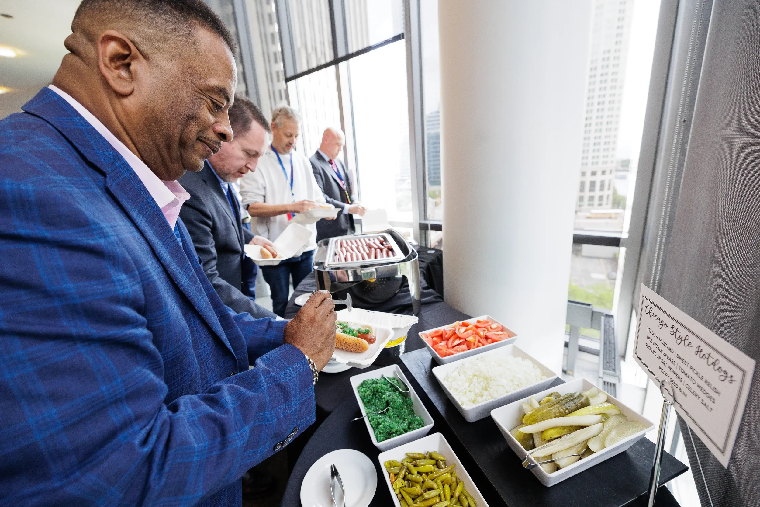 Attendees serve themselves at food station during Orlando corporate conference reception with skyline views