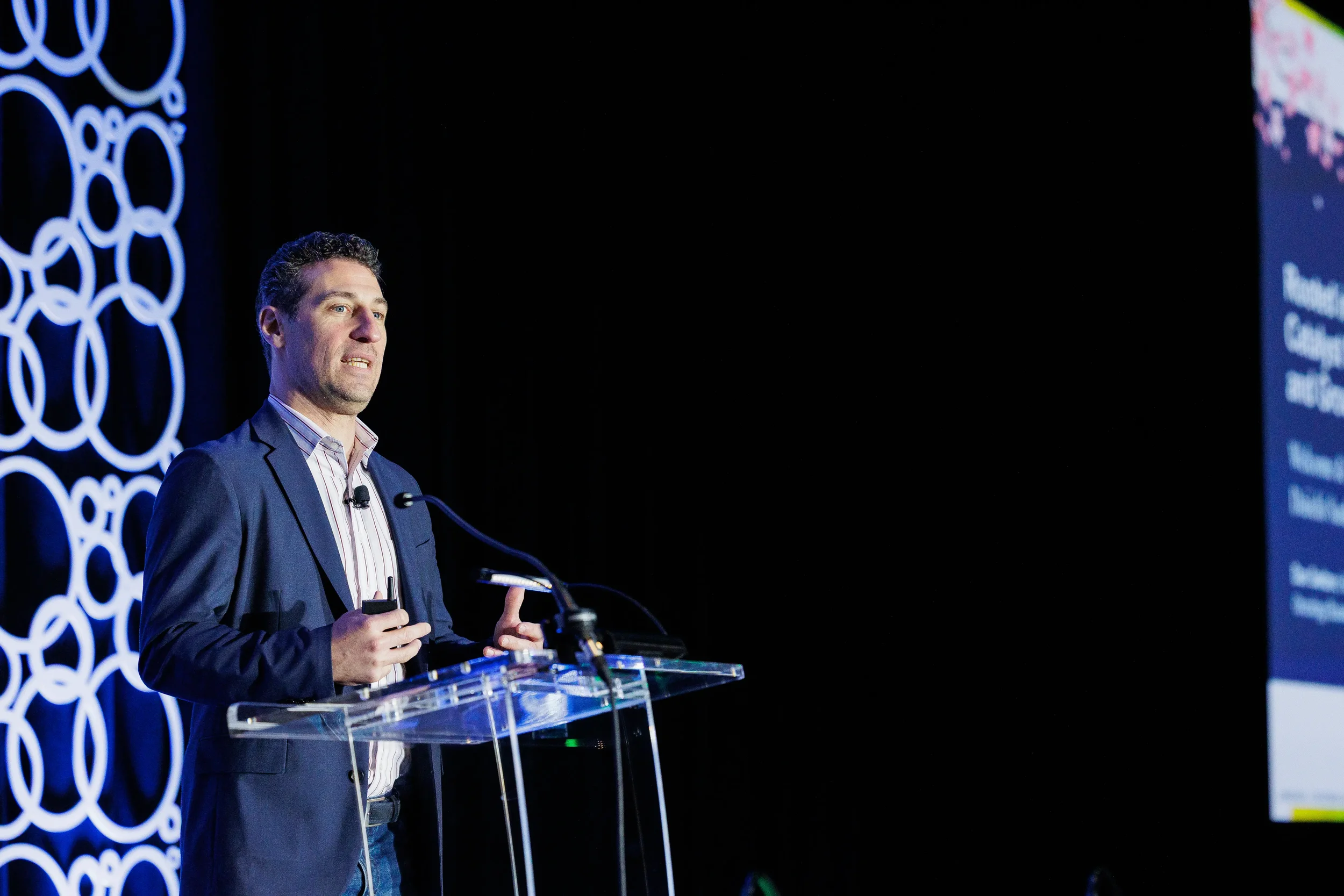 Speaker gestures while presenting from podium on stage at Chicago industry conference