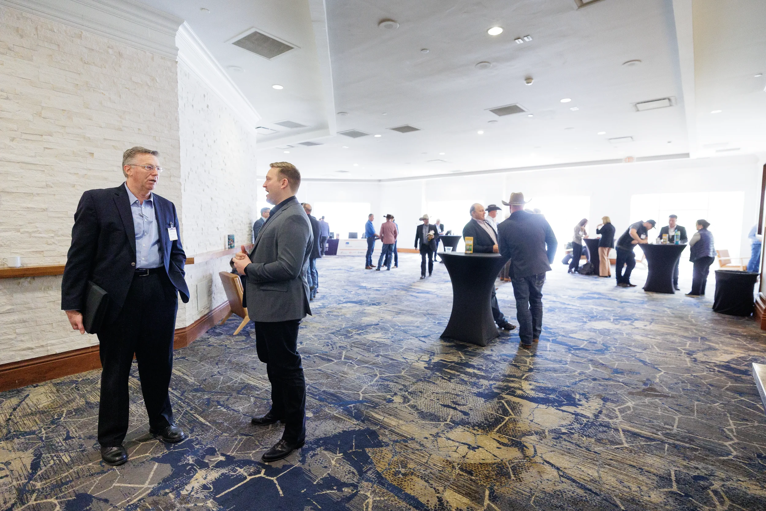 Two attendees converse in hallway during networking break at Chicago corporate conference