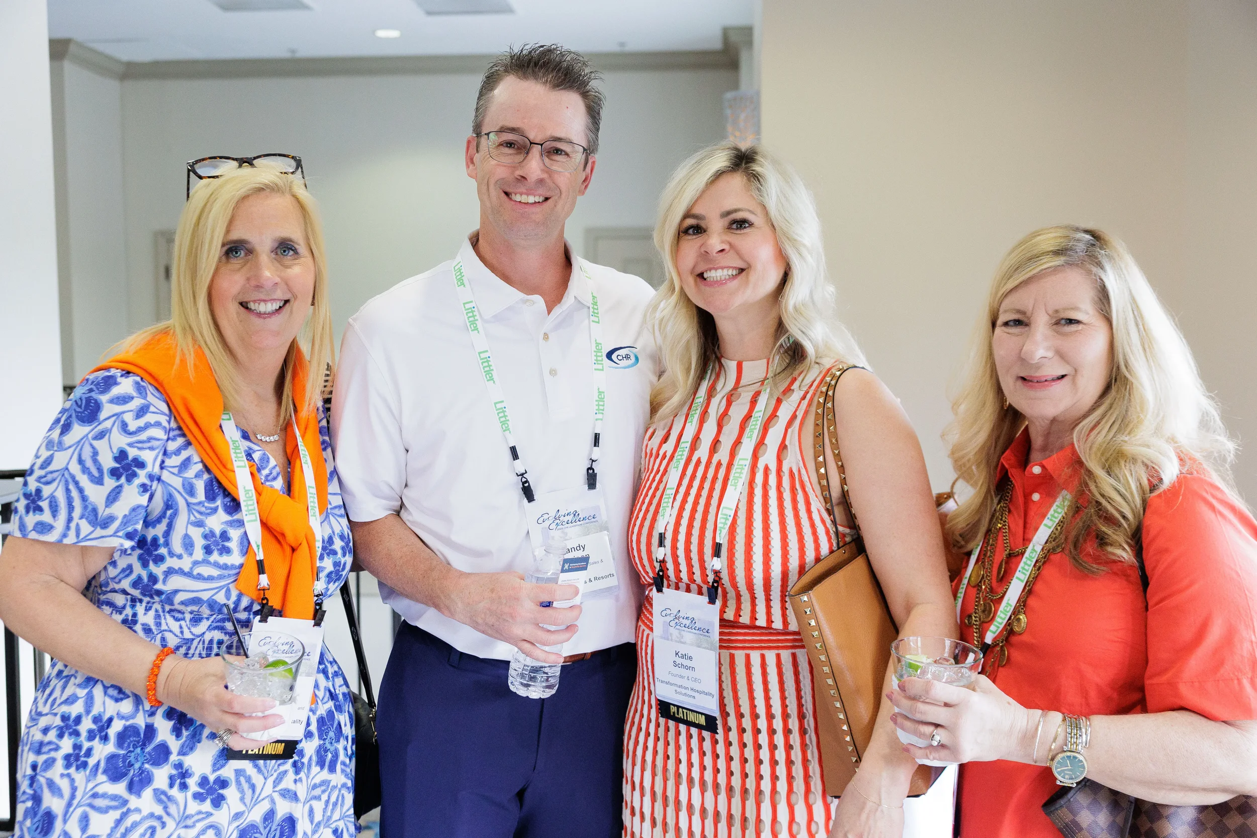 Four attendees with lanyards smile and pose together at Chicago corporate conference networking reception