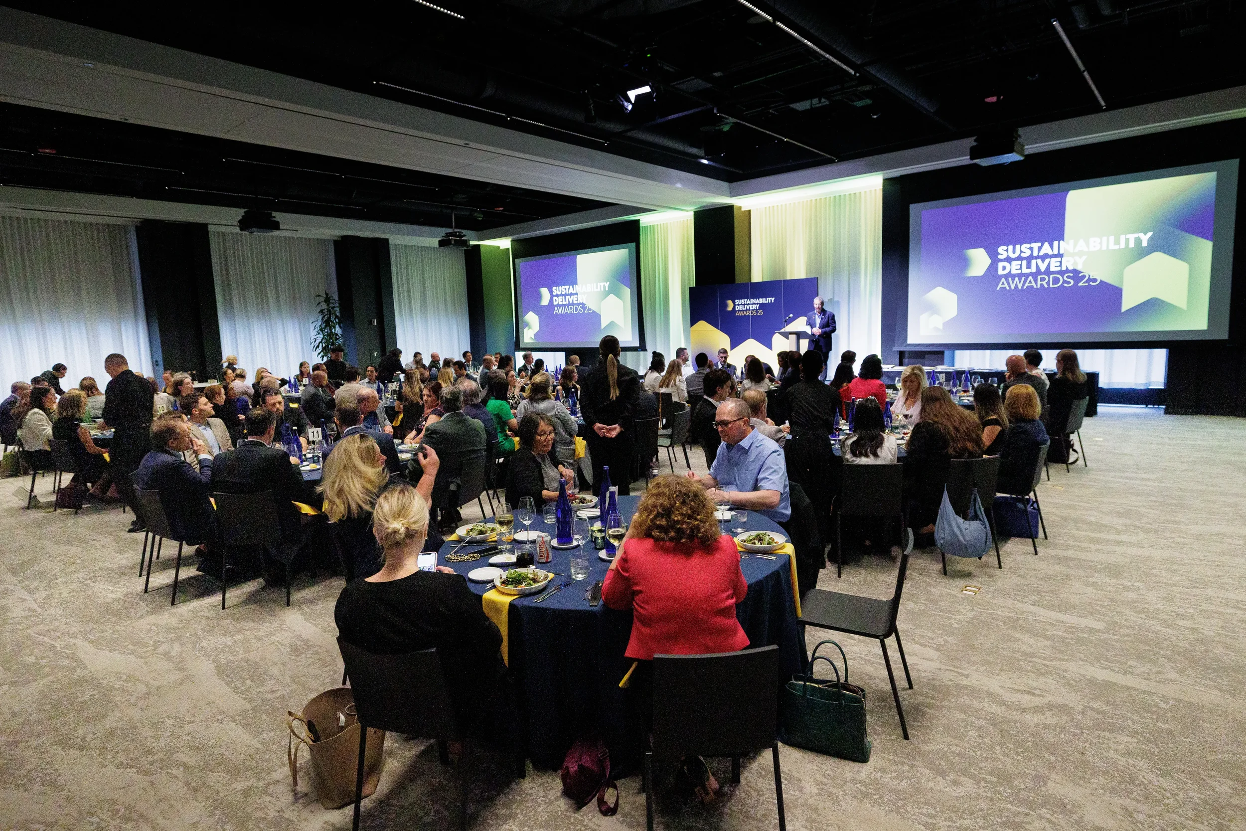 Wide view of awards dinner with attendees seated at tables during Orlando corporate conference