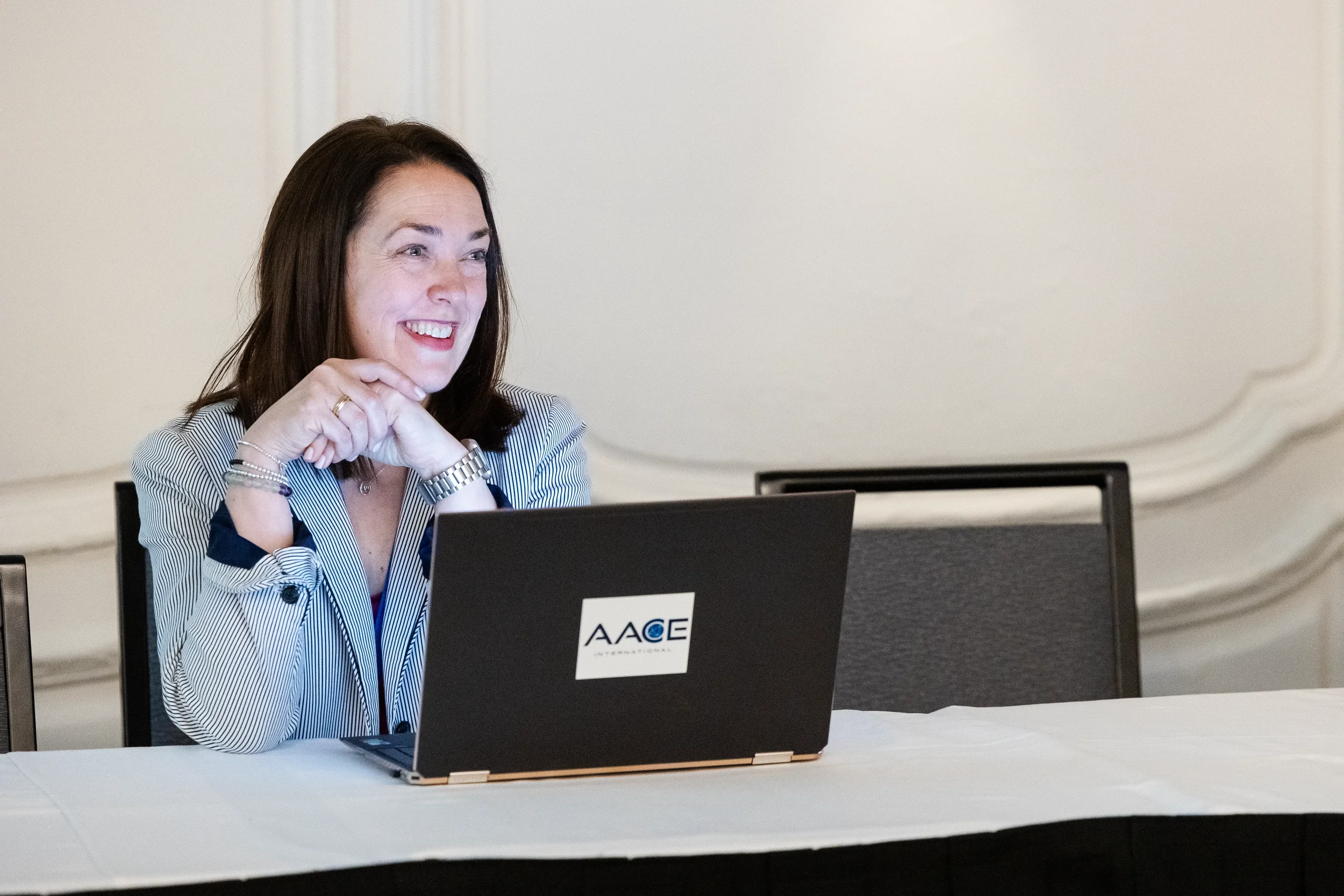 Smiling conference organizer at registration table with AACE International laptop in Orlando
