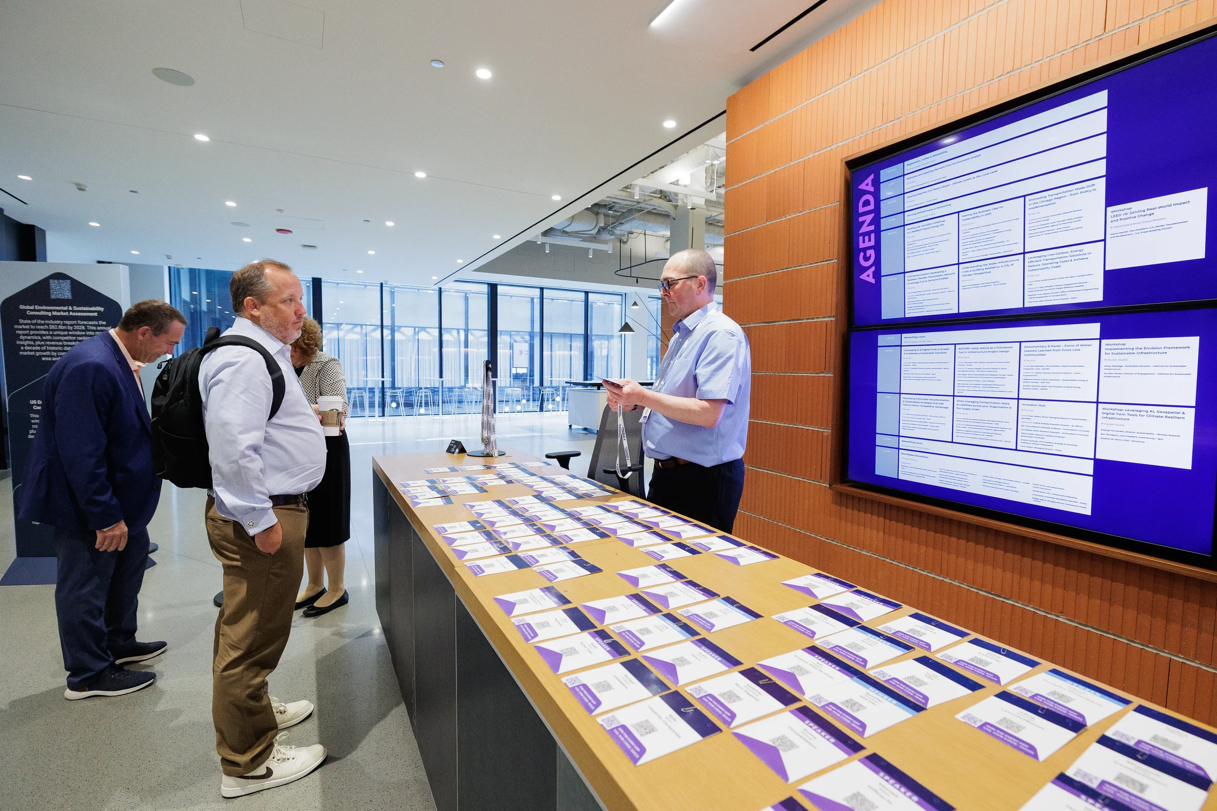 Attendees review agenda display near badge table at Orlando corporate conference registration