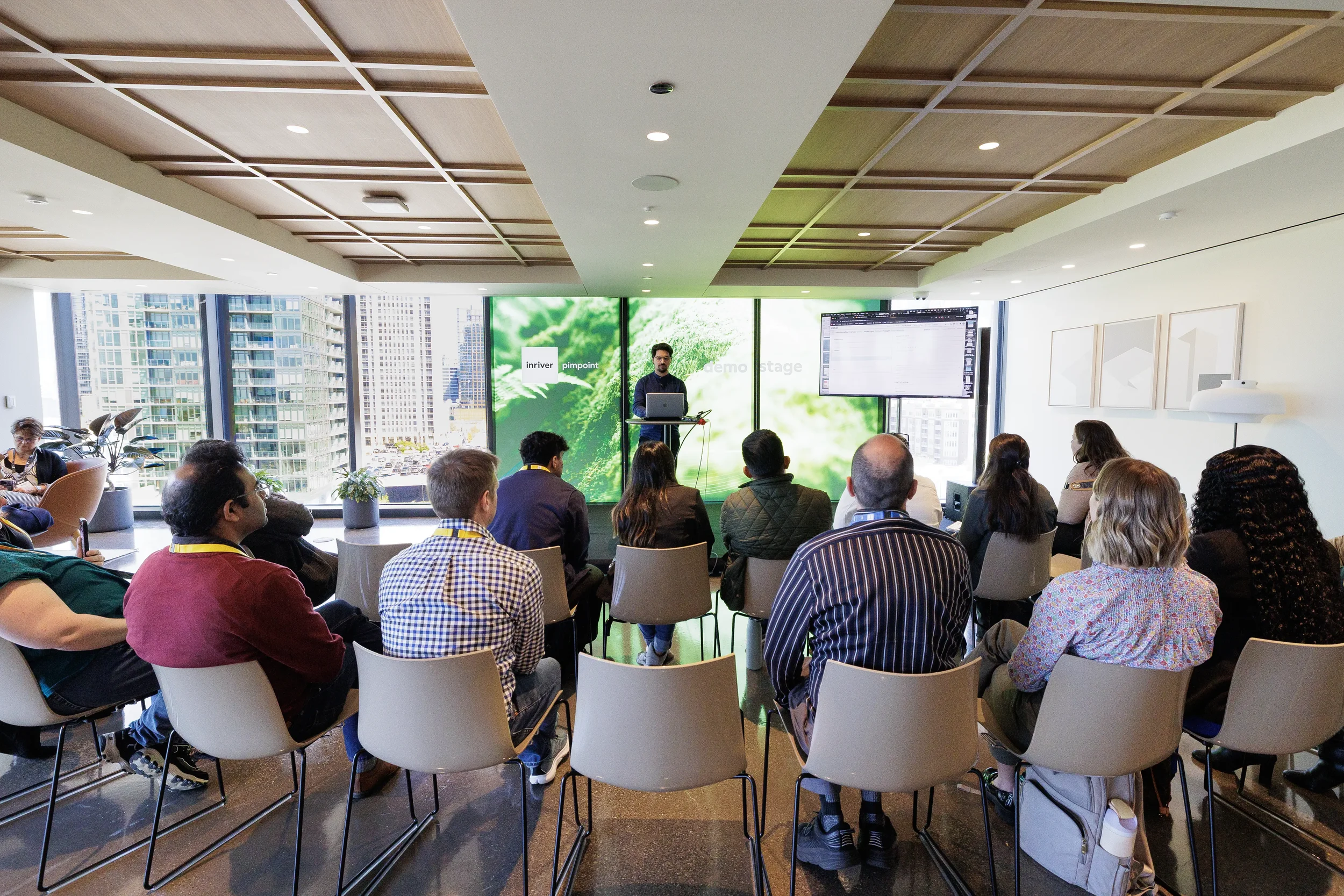 Presenter gives laptop demo to seated audience in breakout room at Chicago corporate conference
