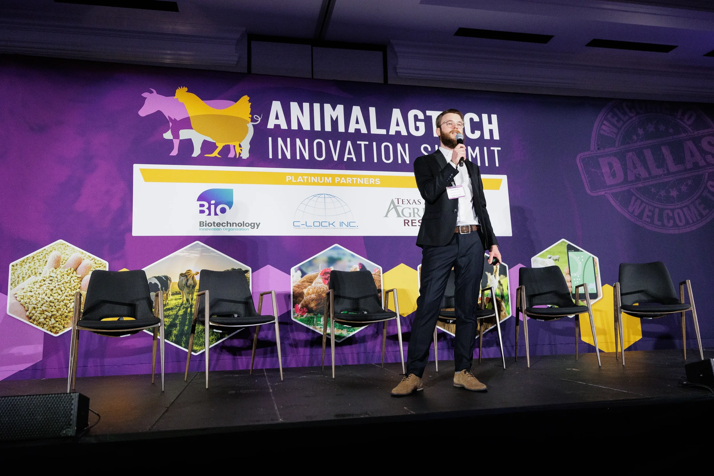 Speaker stands on stage with microphone and clicker during Chicago corporate event presentation