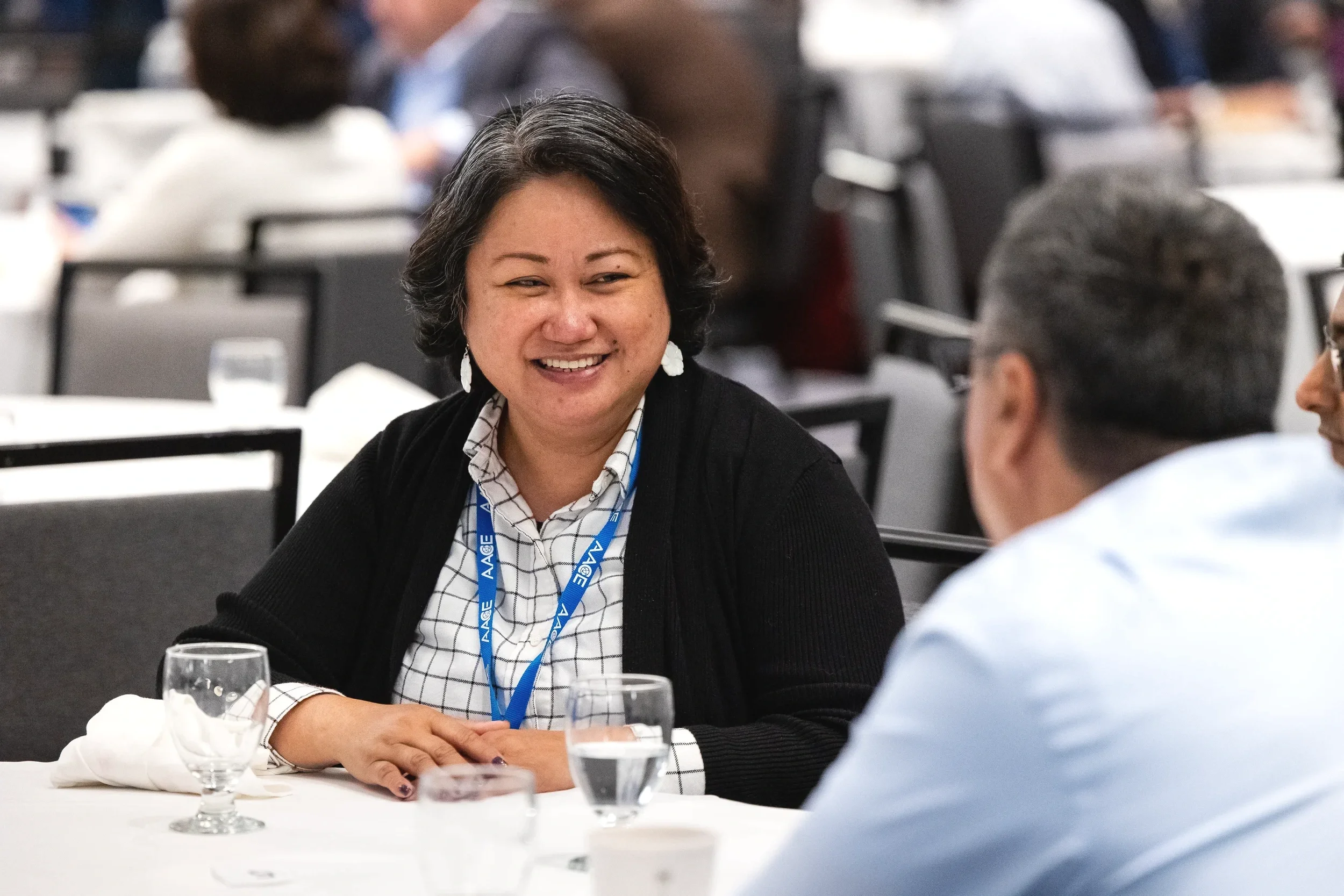 Attendee smiles during table conversation at AACE International conference luncheon in Chicago