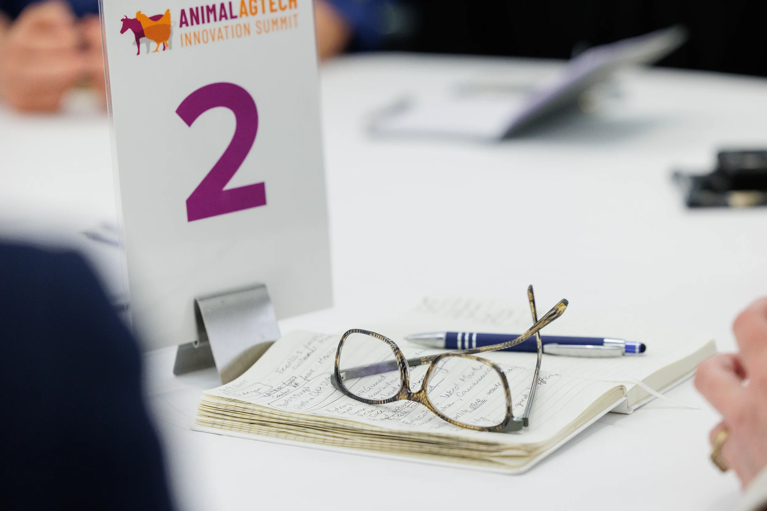 Notebook and glasses rest on table beside numbered signage at Chicago industry conference