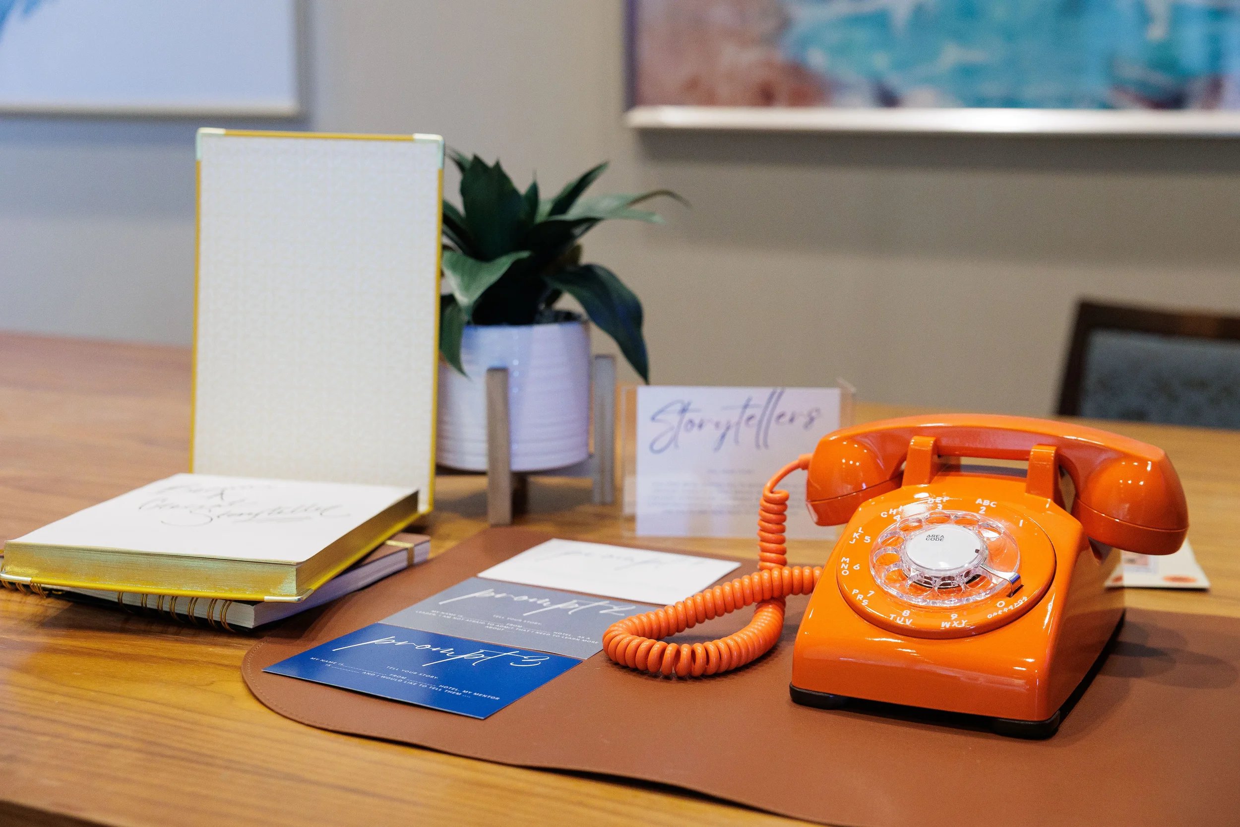 Branded storytelling activity table with retro orange rotary phone at Orlando corporate conference