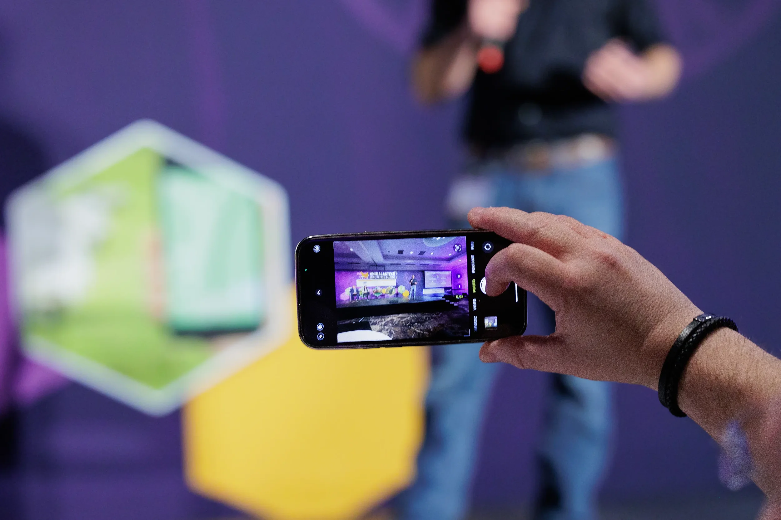 Attendee takes photo of branded stage session on phone at Chicago corporate conference