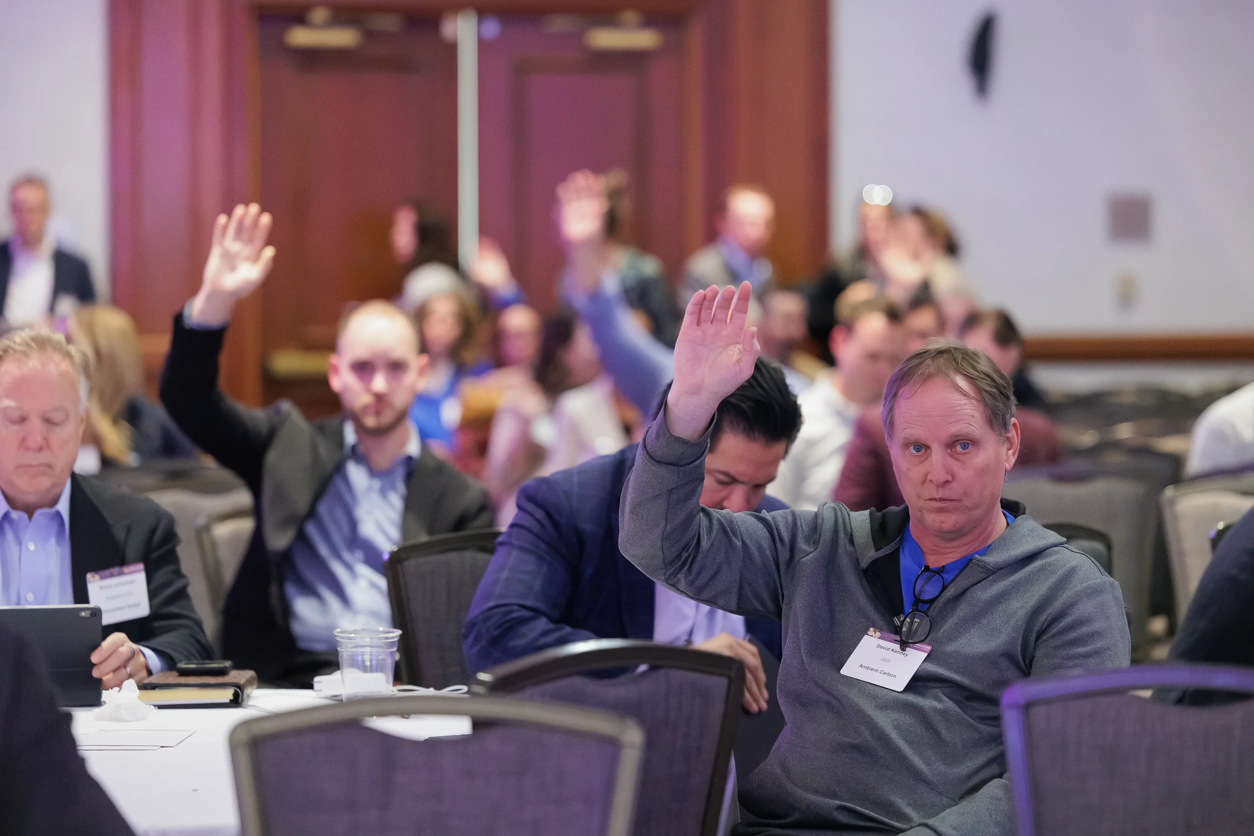 Attendees raise hands to respond during session at Orlando corporate conference