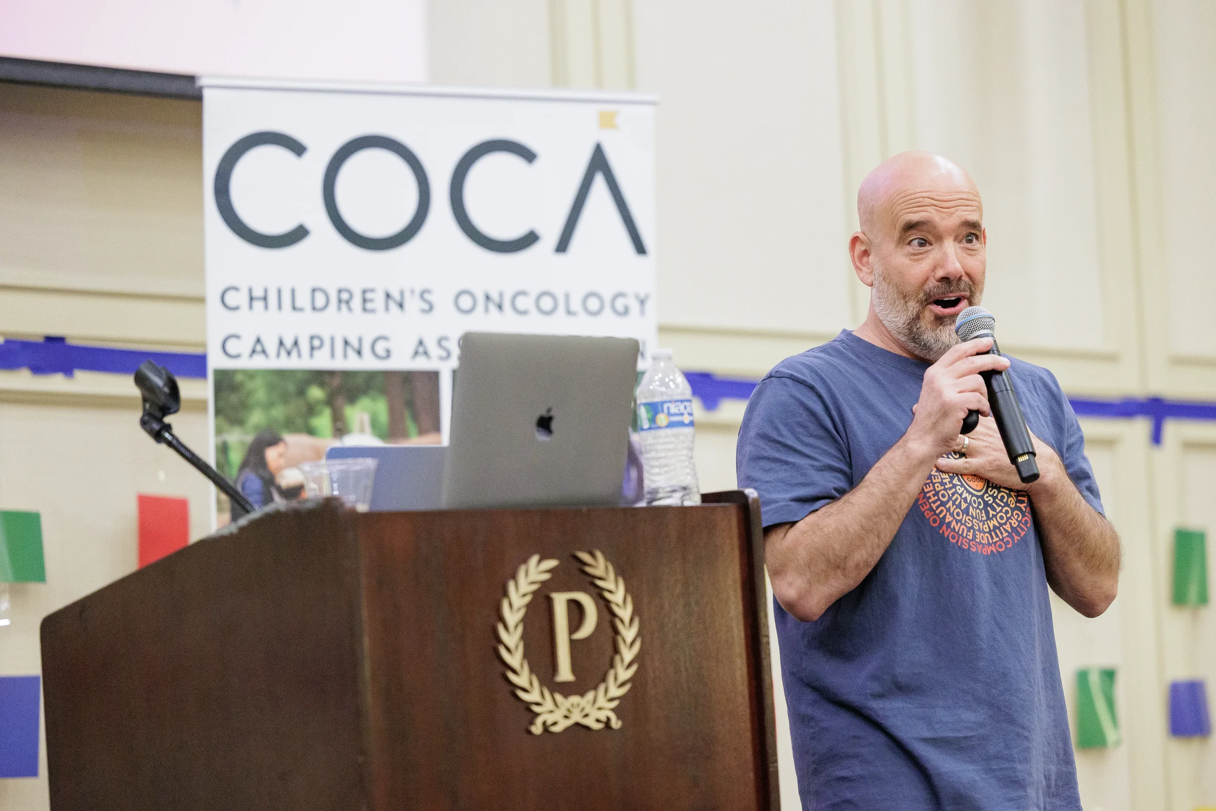 Speaker addresses audience with microphone beside podium at Orlando nonprofit conference event