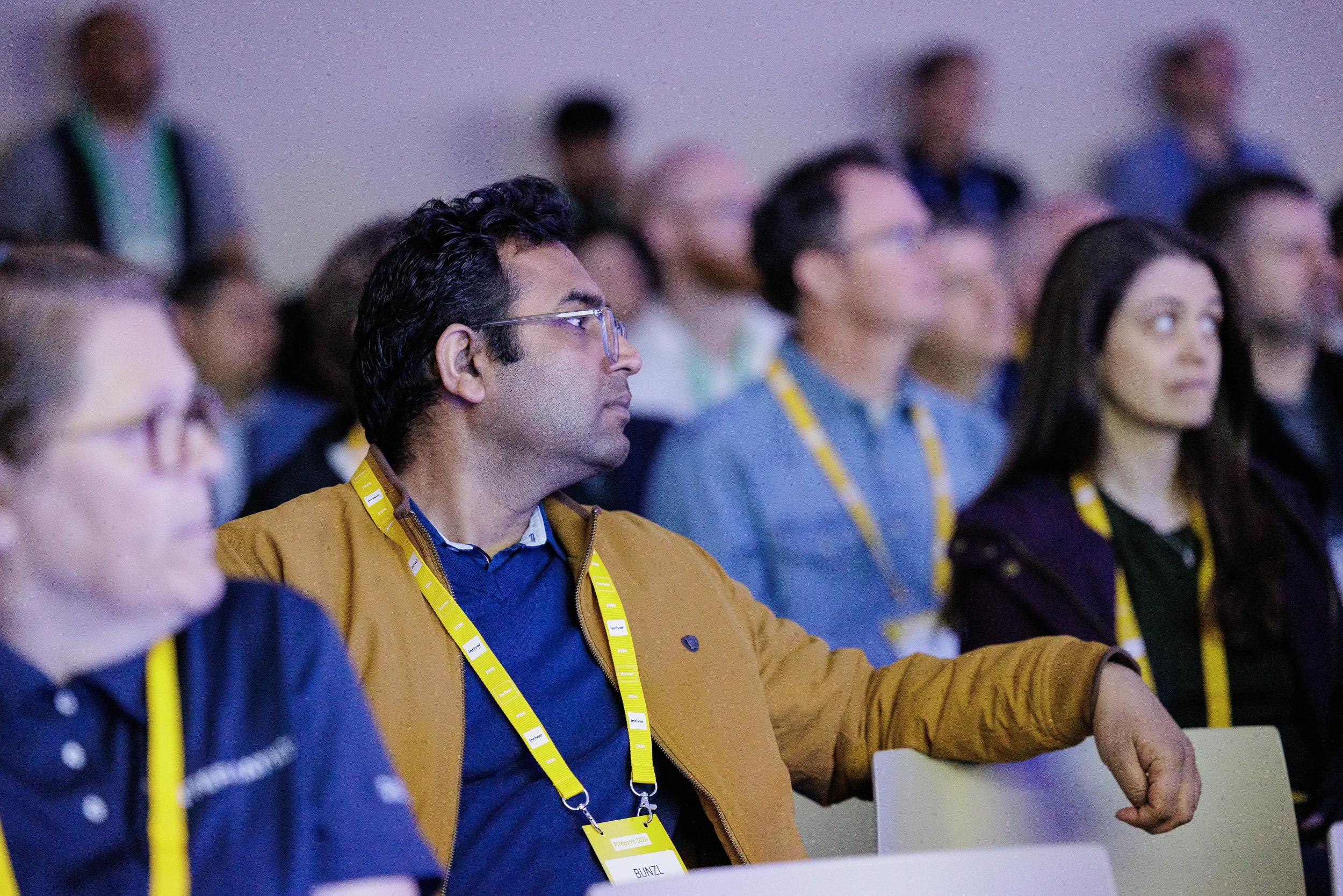 Attendees with yellow lanyards watch session intently in audience at Chicago industry conference
