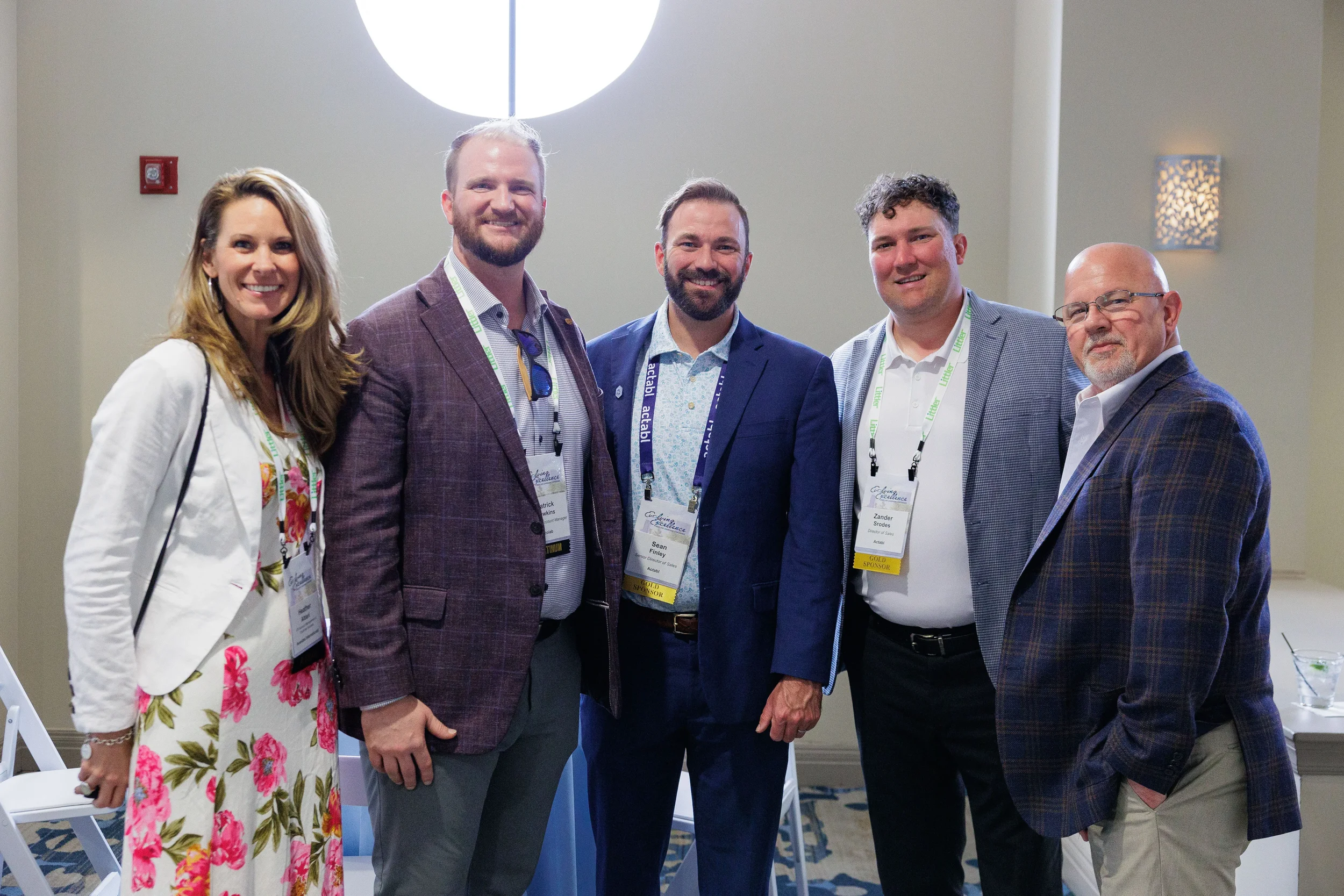 Group of five attendees with lanyards pose together smiling at Chicago corporate networking event