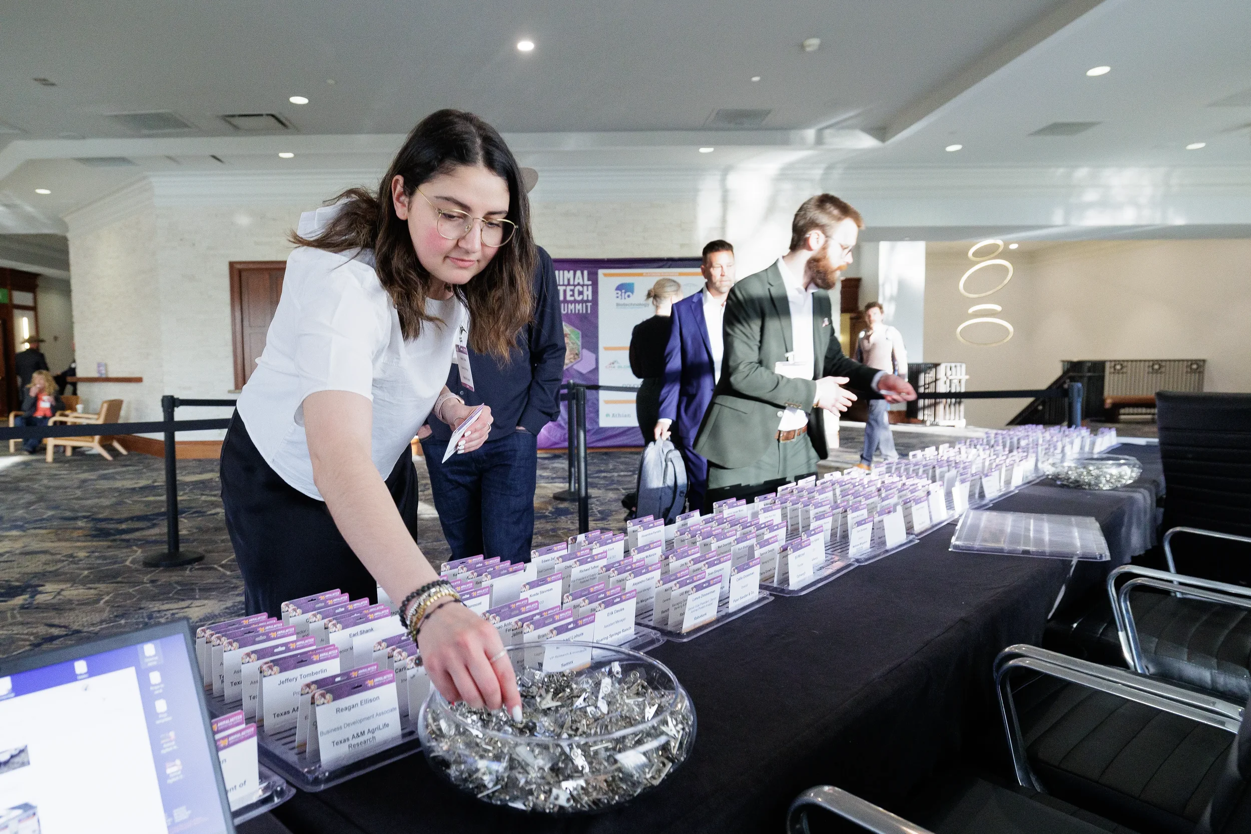 Attendee picks up name badge at registration table during Chicago industry conference