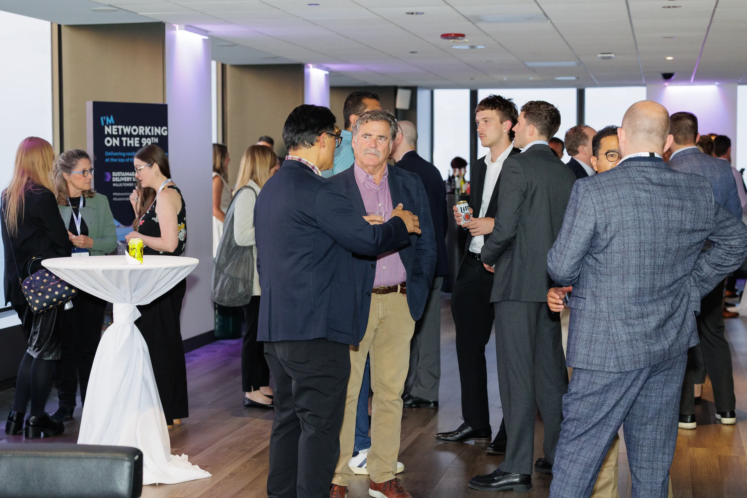 Attendees network together during Orlando corporate event reception with skyline views