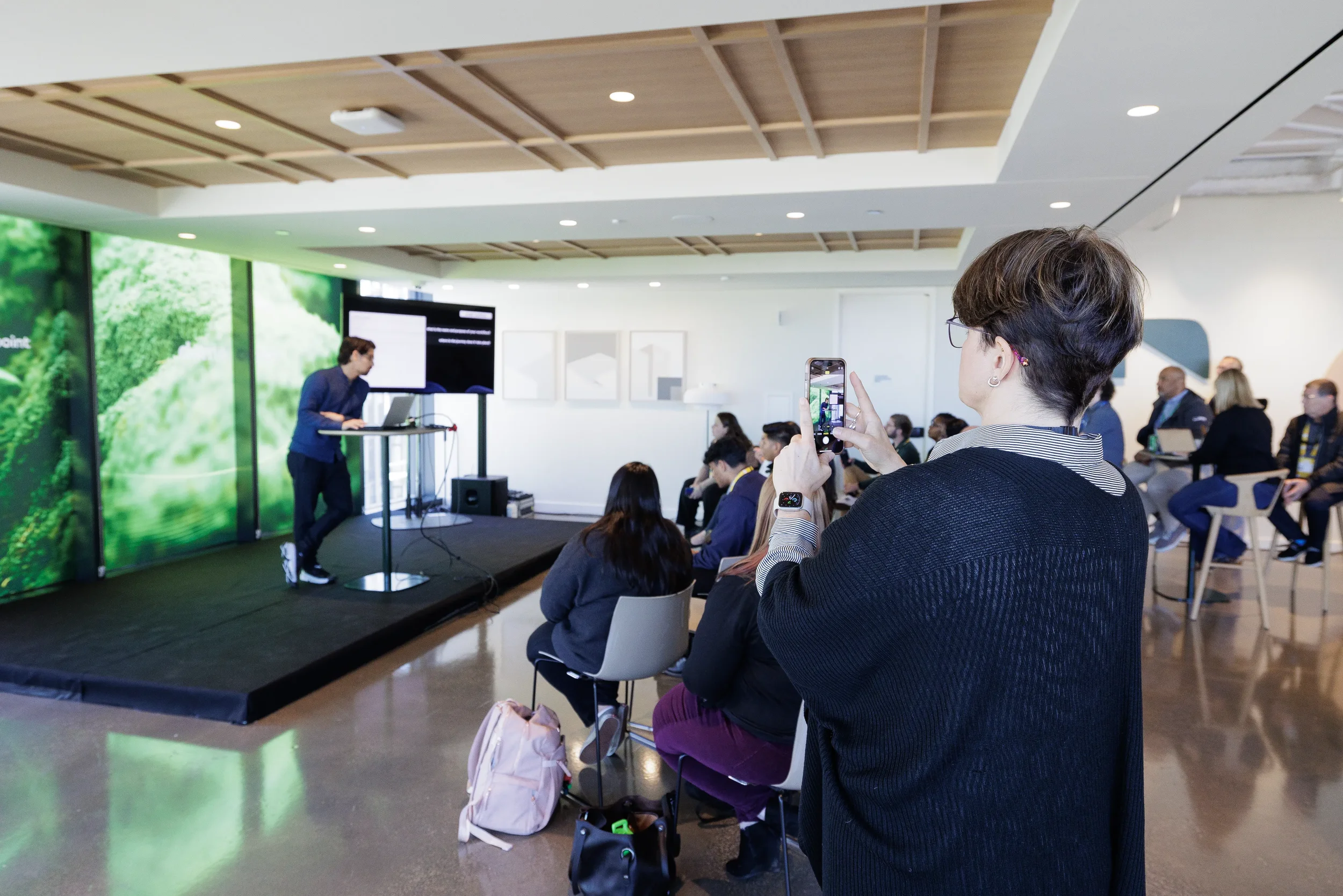 Attendee photographs presenter with smartphone during breakout session at Orlando industry conference