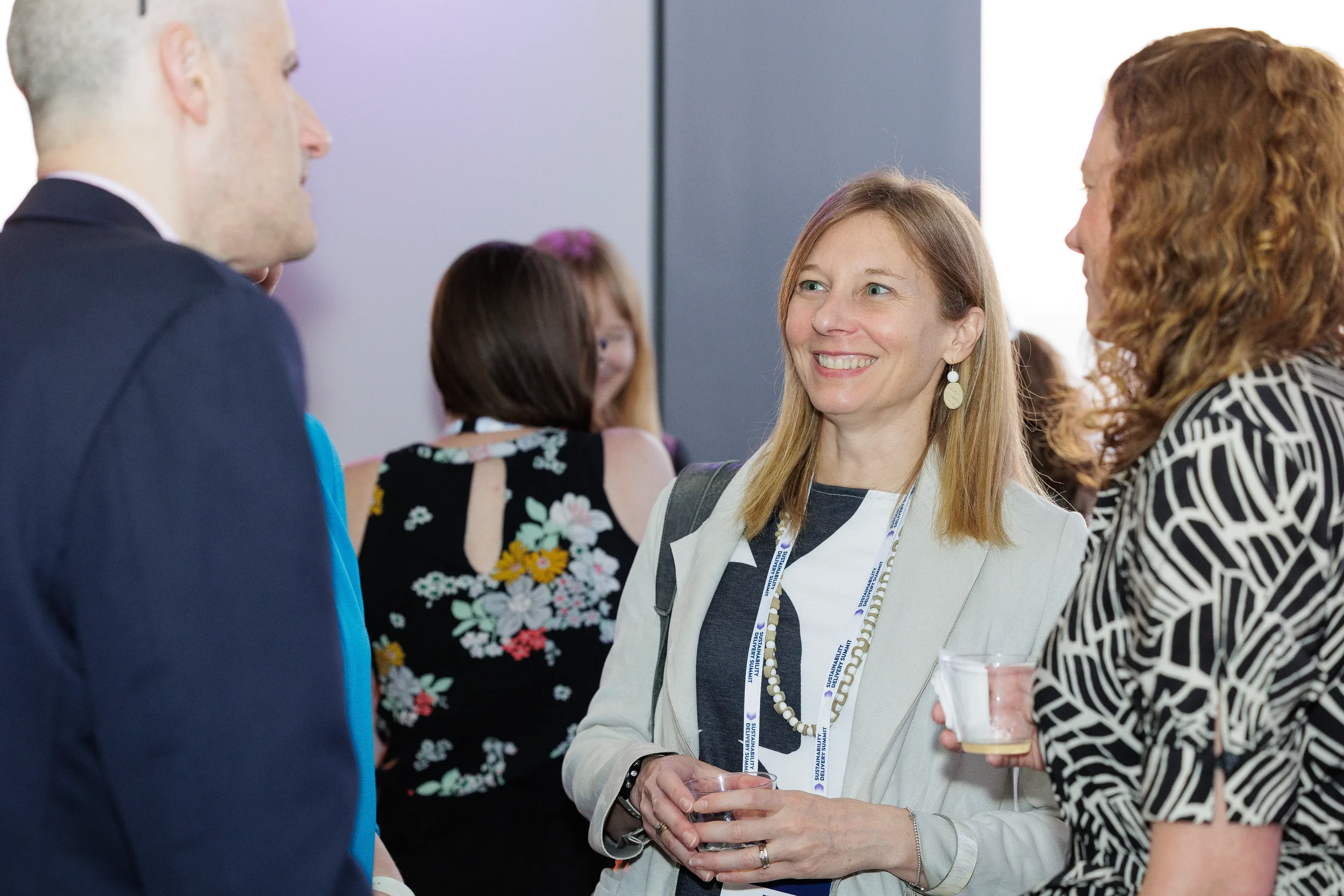 Attendees converse and smile while holding drinks at Orlando corporate event reception
