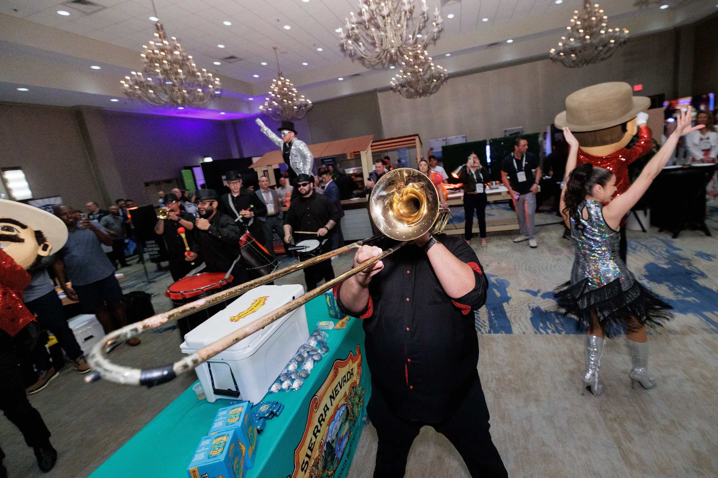 Trombone player performs alongside fringe dancer and stilt performer at Orlando corporate event reception