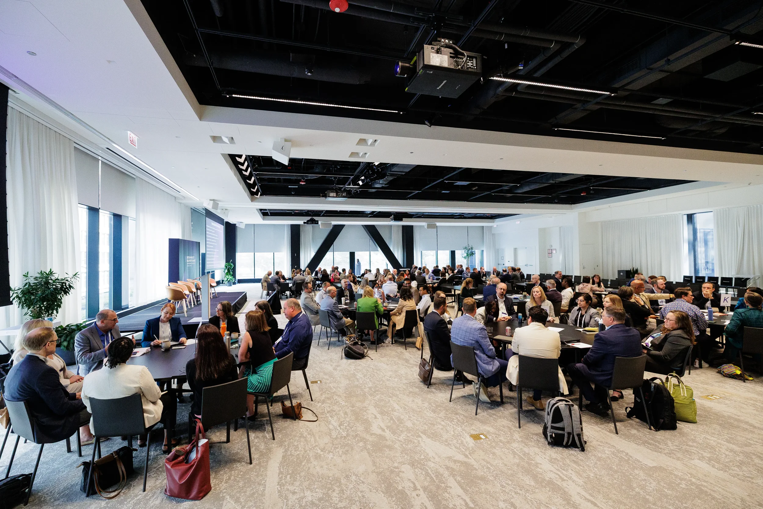 Wide view of conference hall with attendees seated at tables during Chicago industry summit