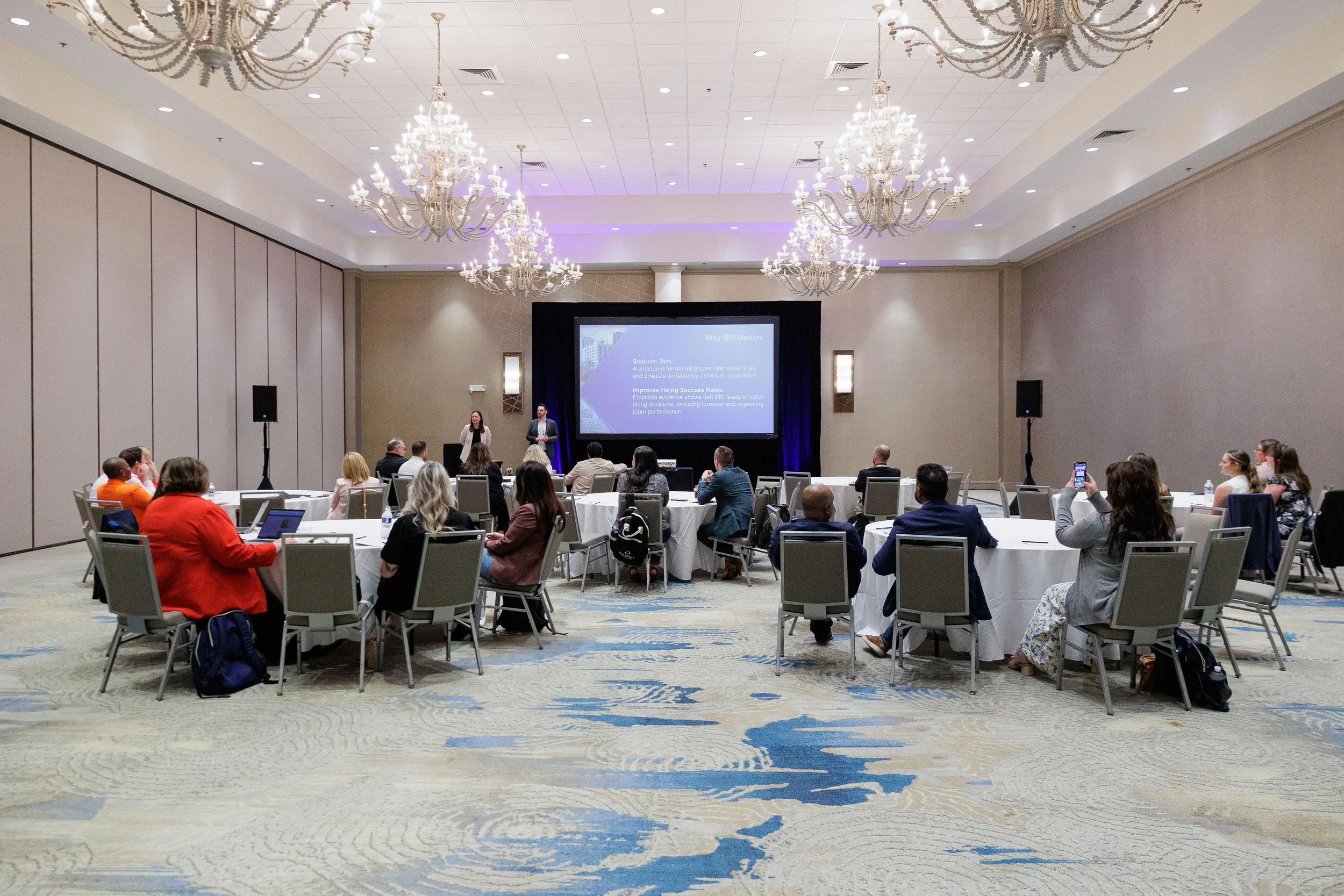Presenters lead breakout session with projection screen for seated attendees at Chicago industry conference